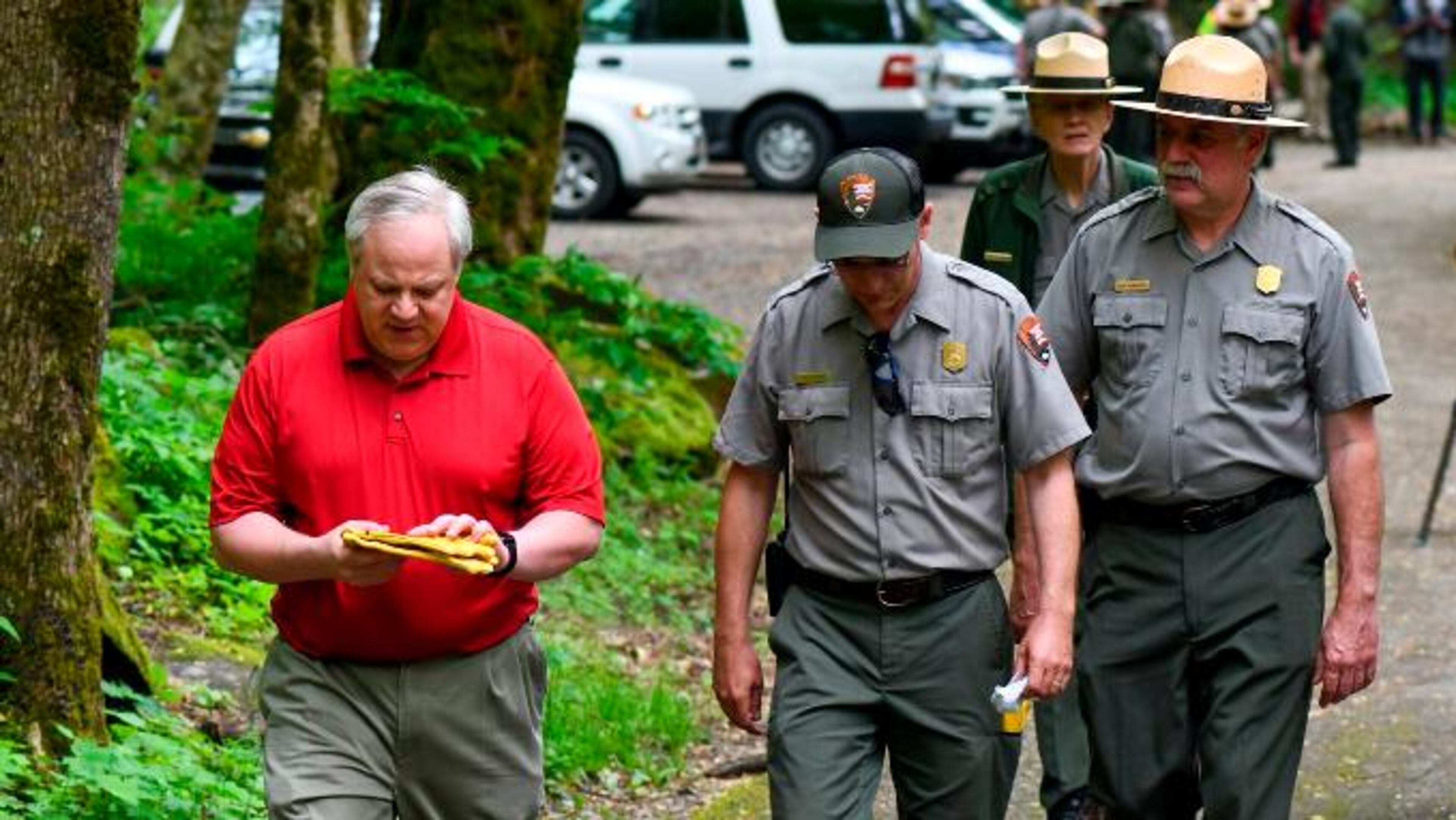 This Wednesday, May 6, 2020 image from a tweet by Interior Secretary David Bernhardt, the Interior Secretary visits with National Parks Service employees at Great Smoky Mountains National Park. While the Interior Secretary asked visitors to social distance when the park reopens on May 9, neither Bernhardt nor park staff wore face masks in the photos, as they talked and walked inches apart during his visit on Tuesday, May 5. (National Parks Service via AP)