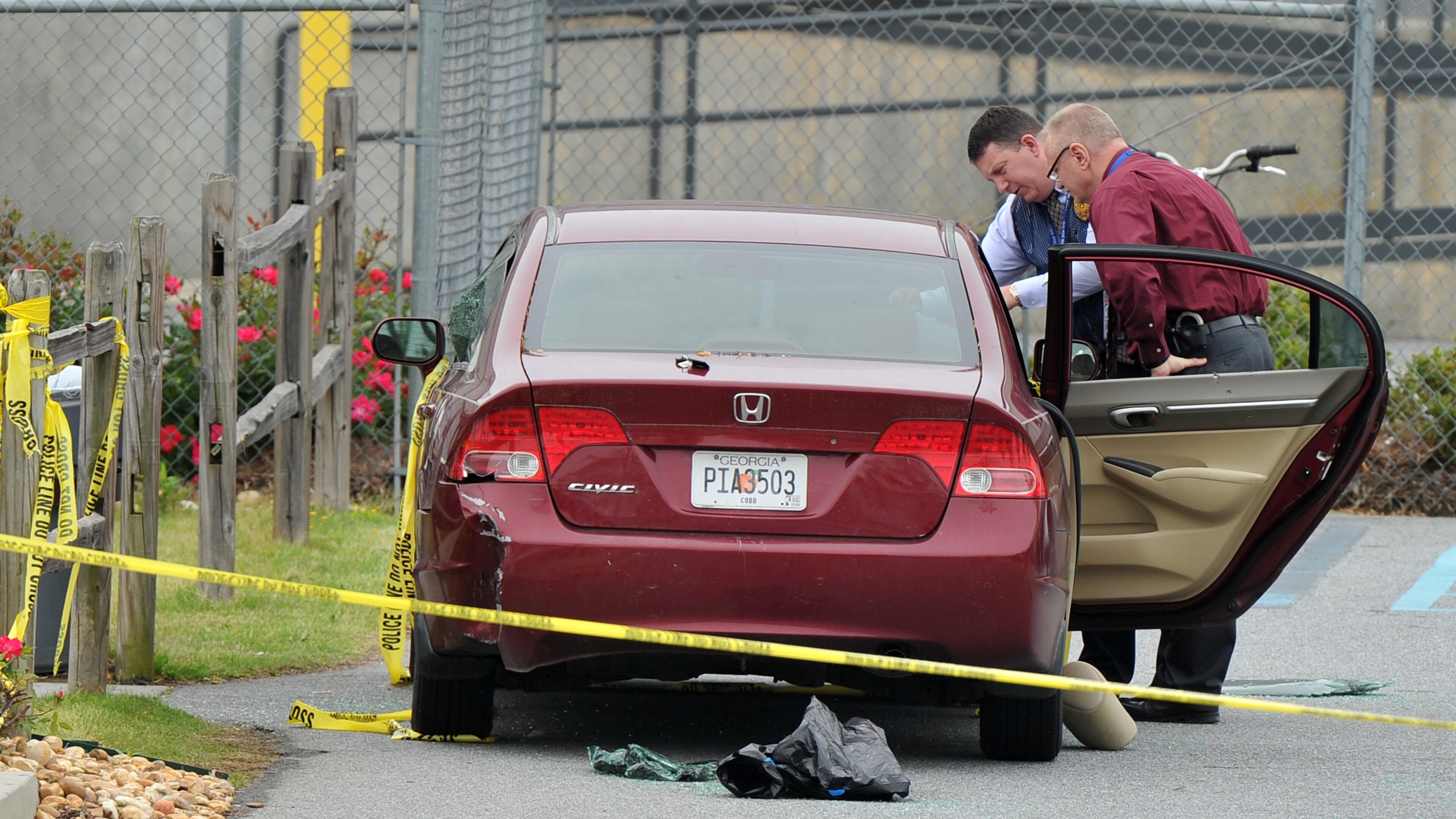 April 29, 2014 Kennesaw, GA: Police officials examine a car located at the scene of the shooting that took place at a FedEx facility in Kennesaw, GA. BRANT SANDERLIN /BSANDERLIN@AJC.COM .