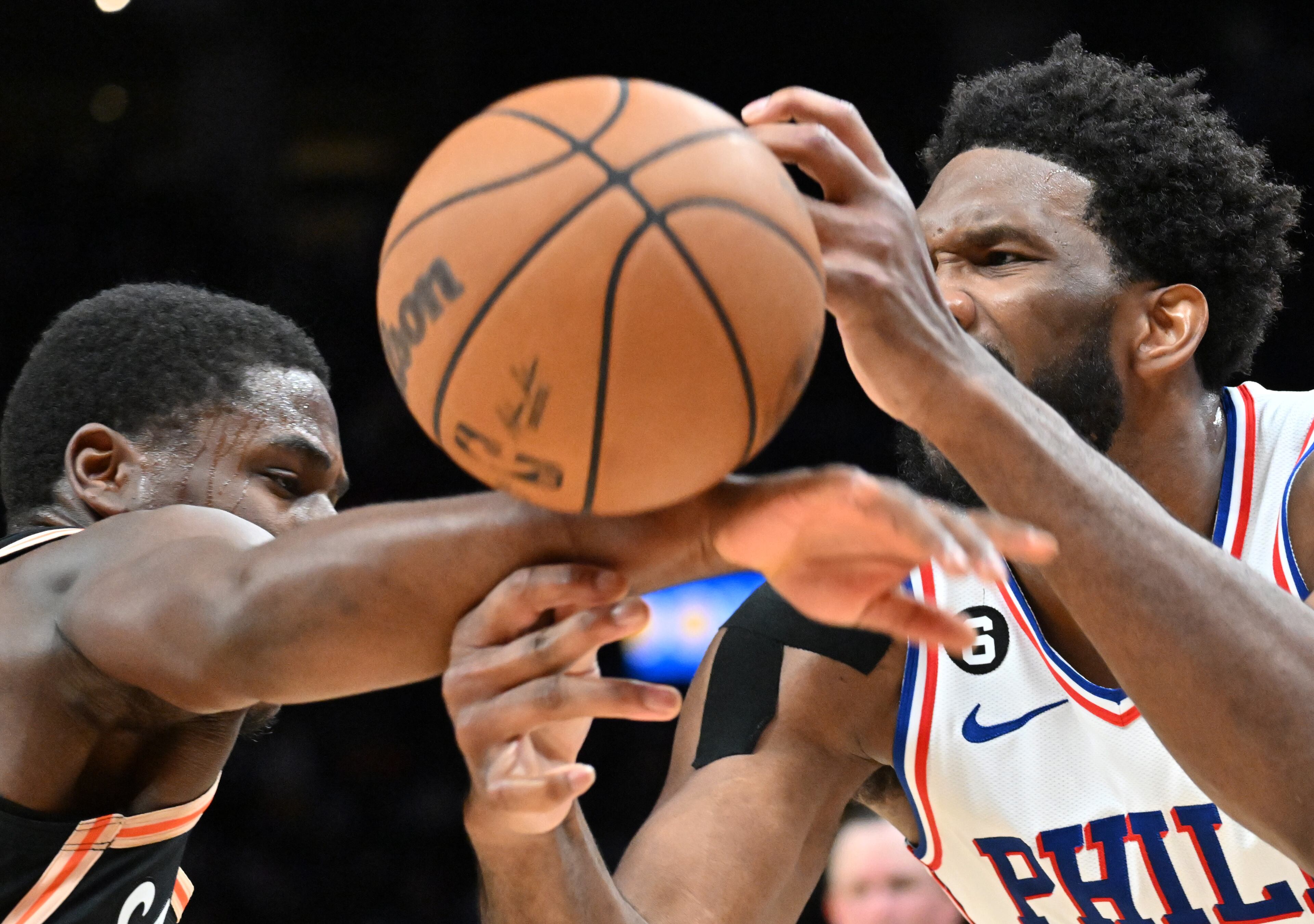 Hawks' guard Aaron Holiday (left) knocks the ball away from Philadelphia 76ers' center Joel Embiid (right). (Hyosub Shin / Hyosub.Shin@ajc.com)