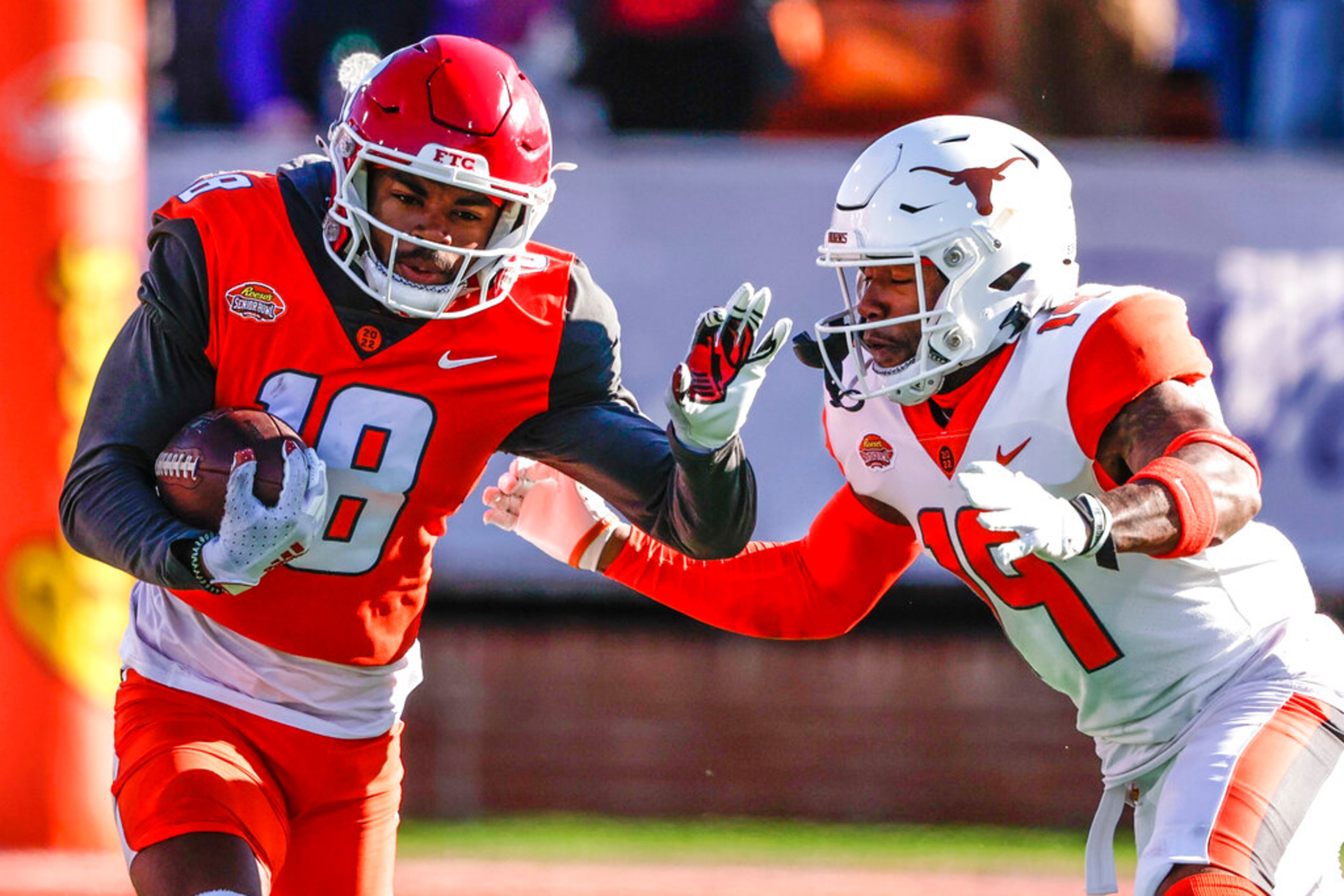 National Team wide receiver Bo Melton (18), of Rutgers, runs the ball while pursued by American Team cornerback Josh Thompson, right, during the third quarter of an NCAA Senior Bowl college football game, Saturday, Feb. 5, 2022, in Mobile, Ala. (AP Photo/Butch Dill)