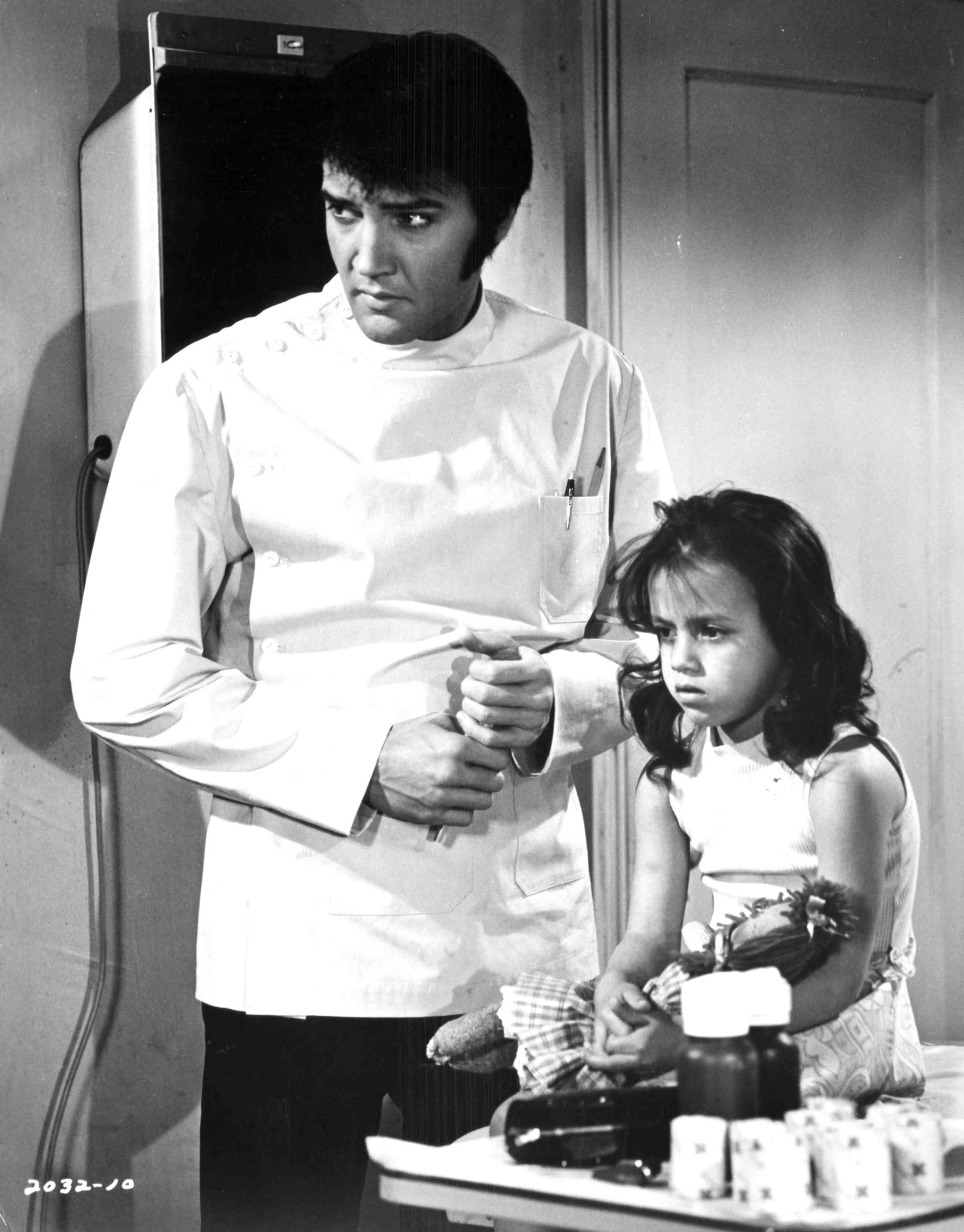 Elvis Presley examines Lorena Kirk, an emotionally disturbed child whose family thinks she is deaf, in a scene from Universal's "Change of Habit" Also starring Mary Tyler Moore, Barbara McNair and Jane Elliot.