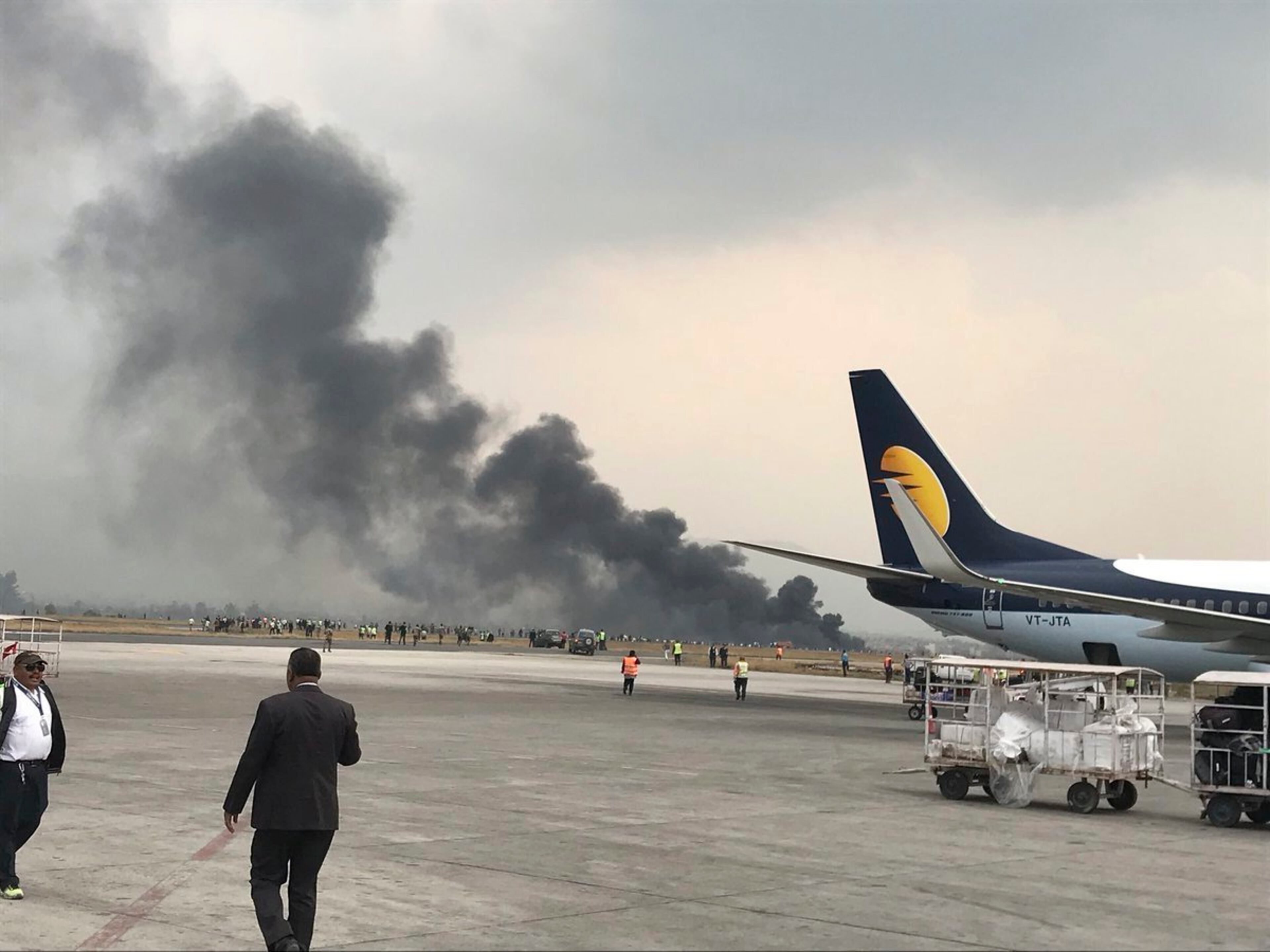 Smoke rises after a passenger plane from Bangladesh crashed at the airport in Kathmandu, Nepal, Monday, March 12, 2018. A passenger plane carrying 71 people from Bangladesh crashed and burst into flames as it landed Monday in Kathmandu, Nepal's capital, killing dozens of people with others rushed to area hospitals, officials said.(Bishnu Sapkota via AP)