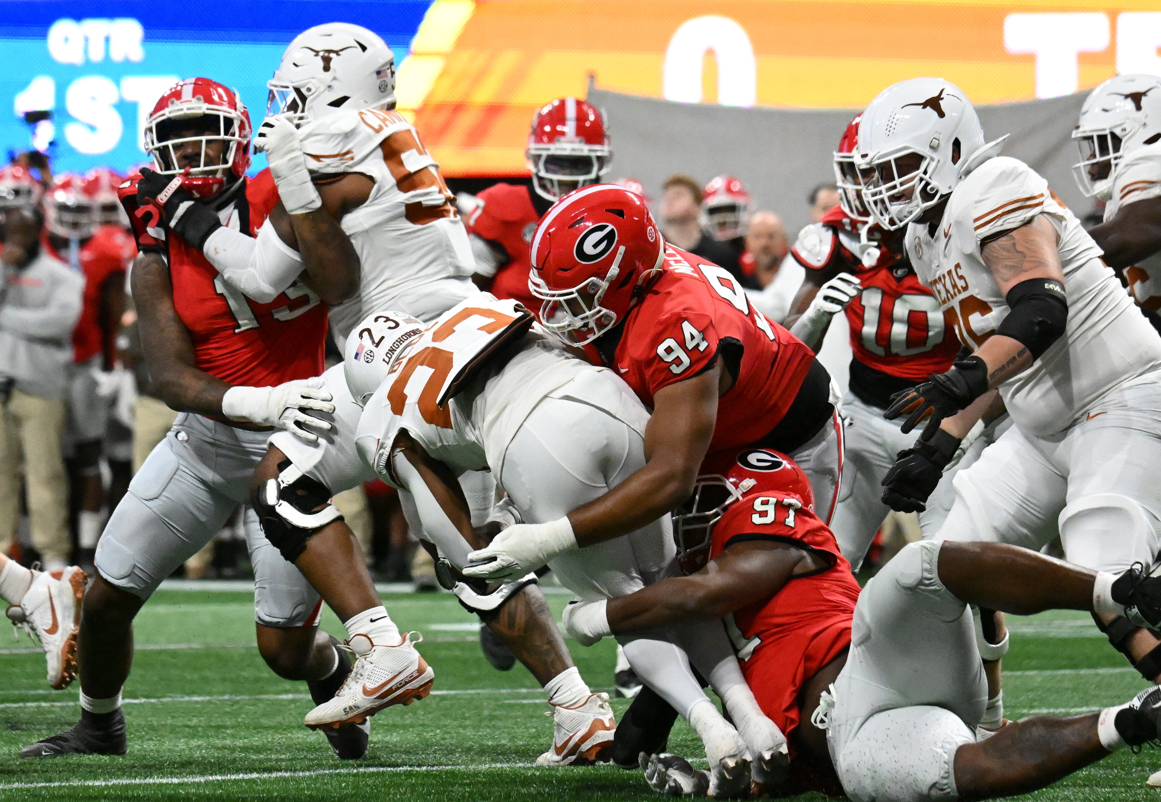 Texas running back Jaydon Blue (23) is stopped by Georgia defensive lineman Xzavier McLeod (94) and Georgia defensive lineman Warren Brinson (97) during the SEC Championship football game at the Mercedes-Benz Stadium, Saturday, December 7, 2024, in Atlanta. (Hyosub Shin / AJC)