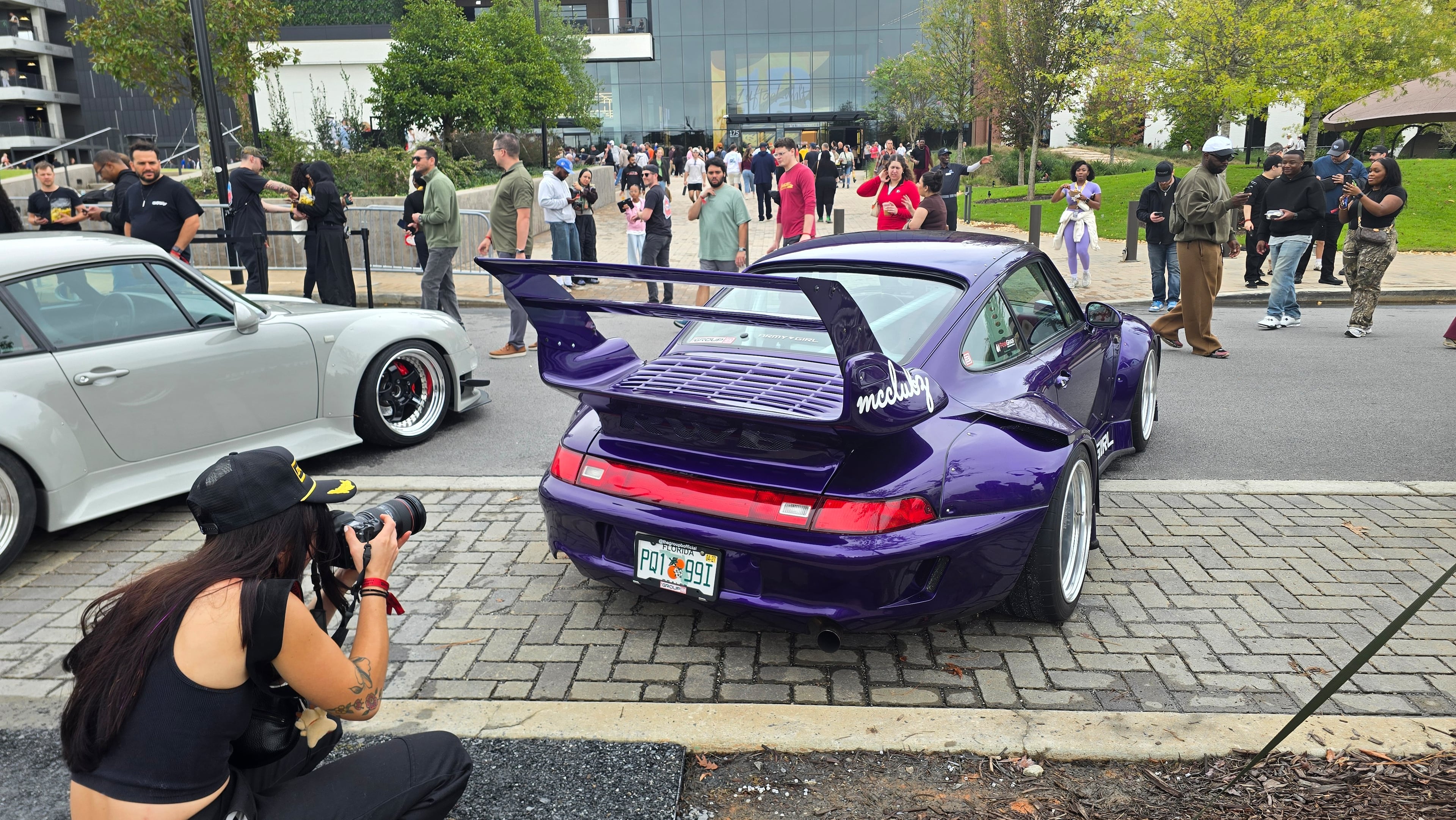 A Luftgekühlt 12 attendee photographs a 1995 Porsche 911 Carrera (993) modified with a widebody kit by Rauh-Welt Begriff (RWB), the Japanese tuning company founded by Akira Nakai, at Town at Trilith near Fayetteville, Ga., on Oct. 10, 2026. (Chris Hardesty/Cox Automotive)