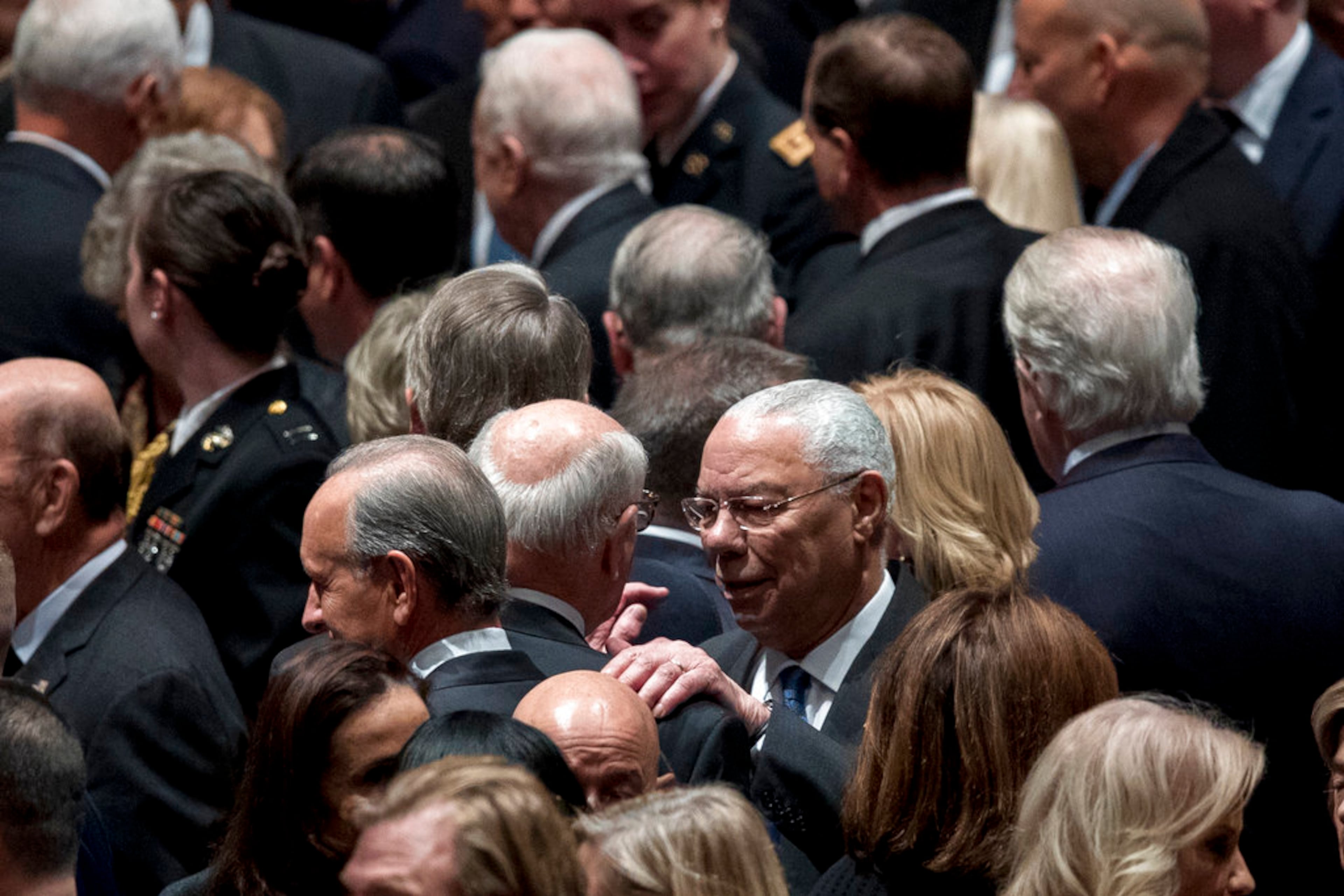 Former Secretary of State Colin Powell, center right, speaks to a guest before a State Funeral for former President George H.W. Bush at the National Cathedral, Wednesday, Dec. 5, 2018, in Washington. (AP Photo/Andrew Harnik, Pool)