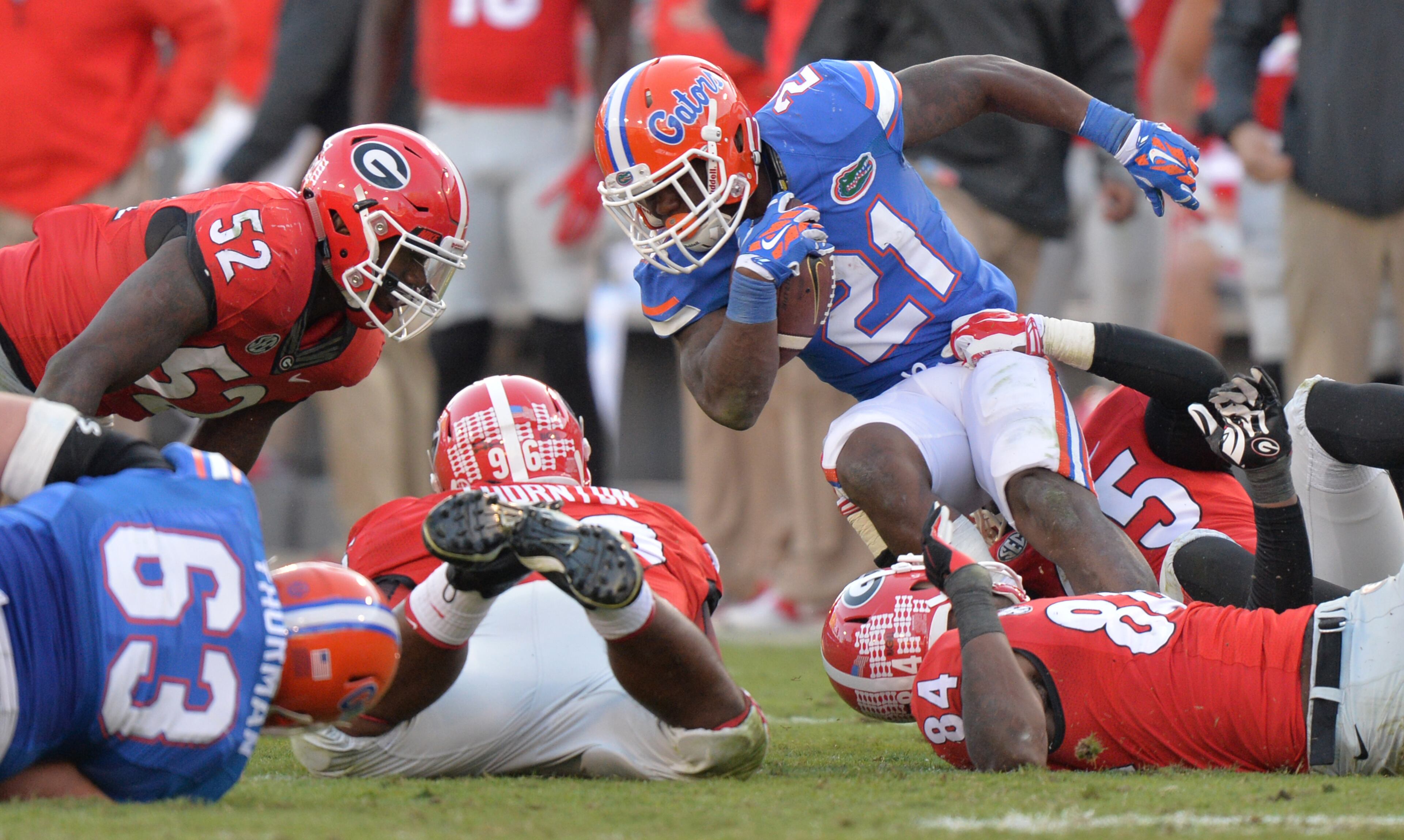 Florida Gators running back Kelvin Taylor, brought down by Georgia Bulldogs linebacker Reggie Carter, rushed for 197 yards and two touchdowns in the Gator's 38-20 win. BRANT SANDERLIN / BSANDERLIN@AJC.COM