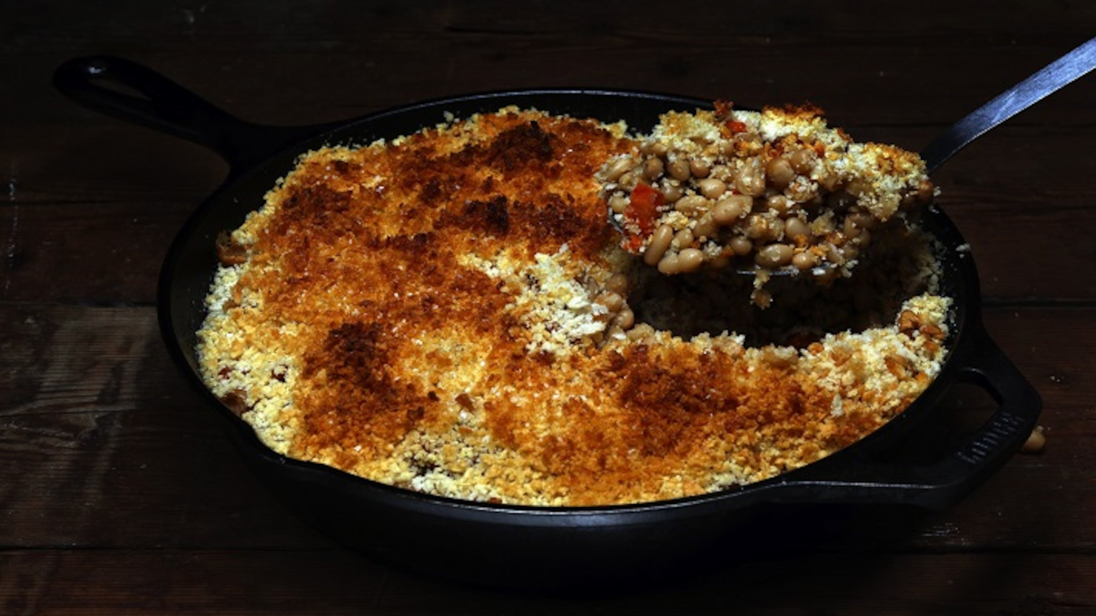 White beans stew with carrots and lots of garlic to make a satisfying dinner underneath a blanket of crisp breadcrumbs. (Terrence Antonio James/Chicago Tribune/TNS)