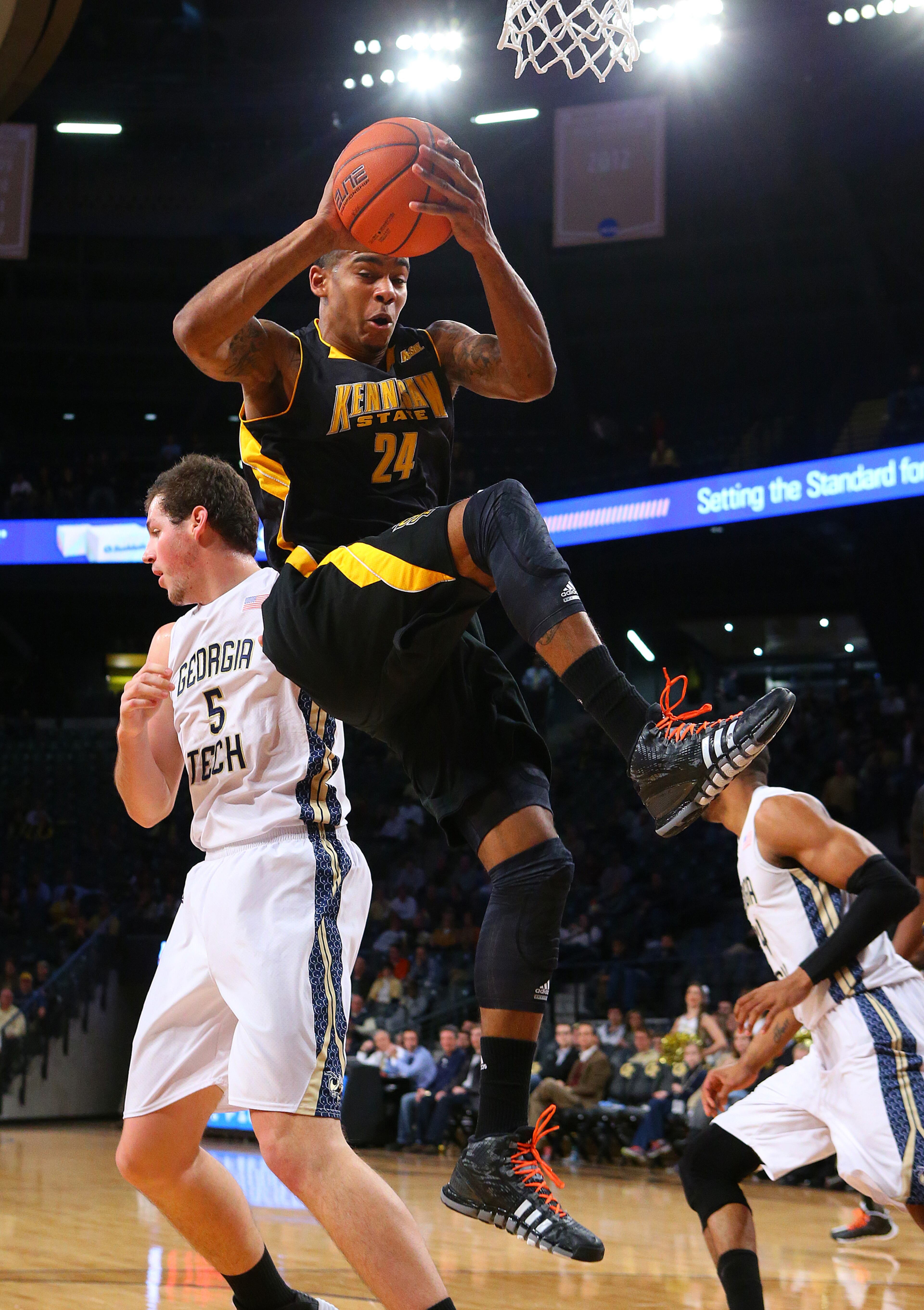 Kennesaw State Owls forward Orlando Coleman grabs a rebound over Georgia Tech center Daniel Miller during the first half of a college basketball game on Monday, Dec. 16, 2013, in Atlanta.