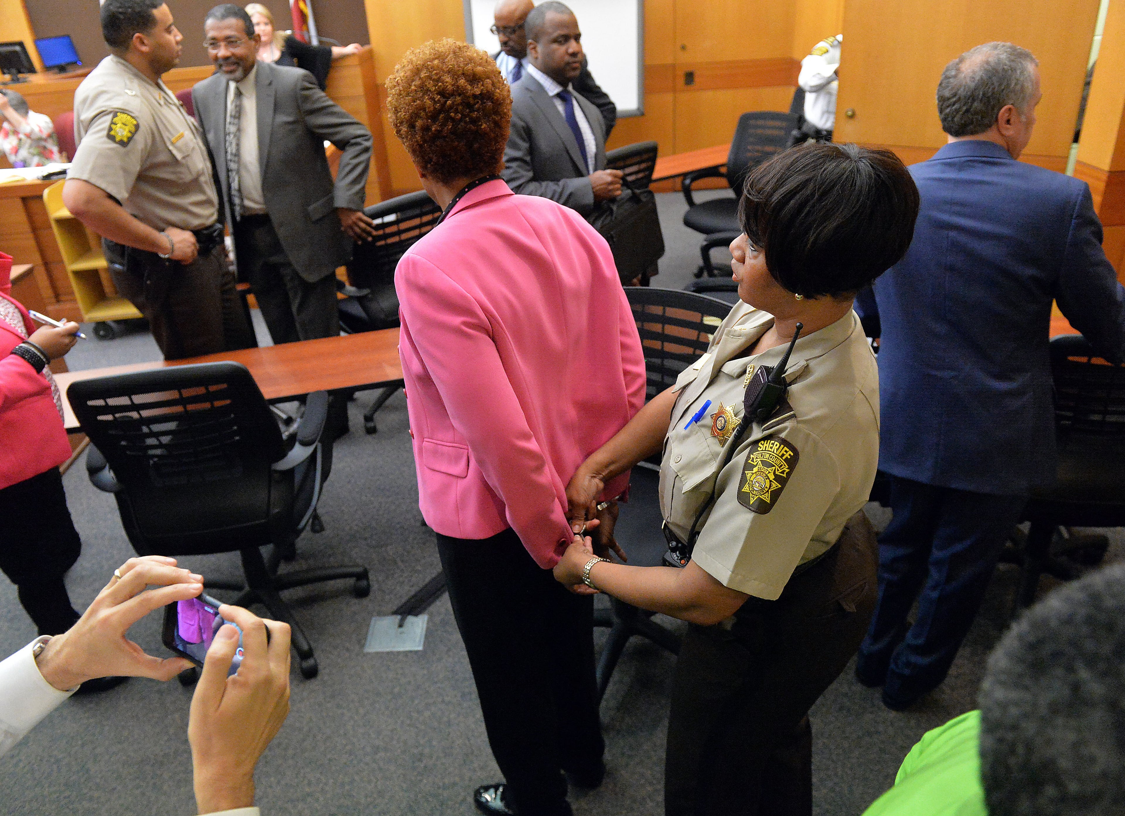 A Fulton Sheriff's Deputy handcuffs former APS SRT Director Sharon Davis Williams following her conviction on Violation of Racketeer Influenced and Corrupt Organizations Act charges Wednesday. A jury of six men and six women rendered their verdicts on the eighth day of deliberations in the Atlanta Public Schools test-cheating trial on Wednesday, April 1, 2015. Jurors sorted through roughly five months of testimony against 12 former educators accused of engaging in a racketeering conspiracy to inflate test scores. (Atlanta Journal-Constitution, Kent D. Johnson, Pool)