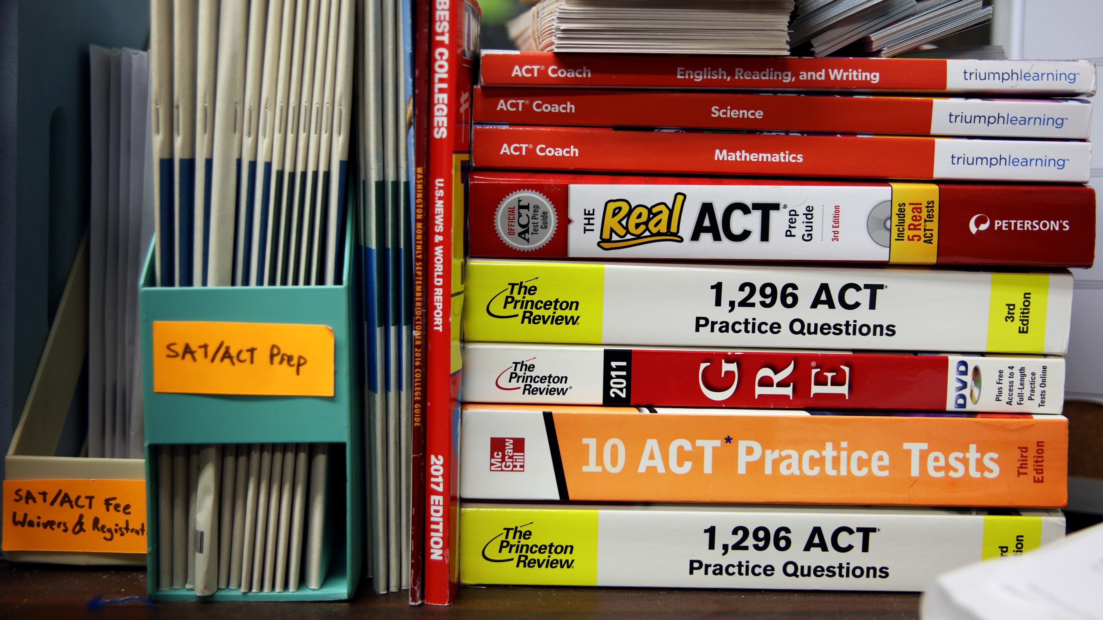 FILE ACT and GRE prep books are stacked in a guidance counselors office at Hobbton High School in Sampson County, N.C., May 19, 2017. Instead of just helping disadvantaged students to catch up with peers, educators are looking for ways to give them more chances to shine in advanced classes and selective schools. (Travis Dove/The New York Times)