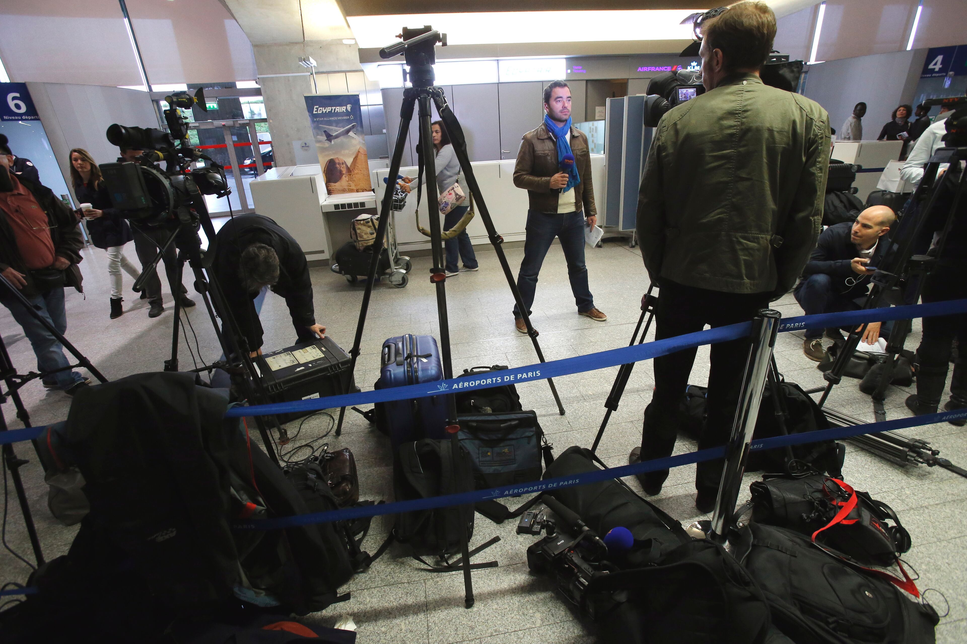 Reporters gather in front of the EgyptAir counter at Charles de Gaulle Airport outside of Paris, Thursday, May 19, 2016. An EgyptAir flight from Paris to Cairo carrying 66 people disappeared from radar early Thursday morning, the airline said. (AP Photo/Raphael Satter) (AP Photo/Michel Euler)