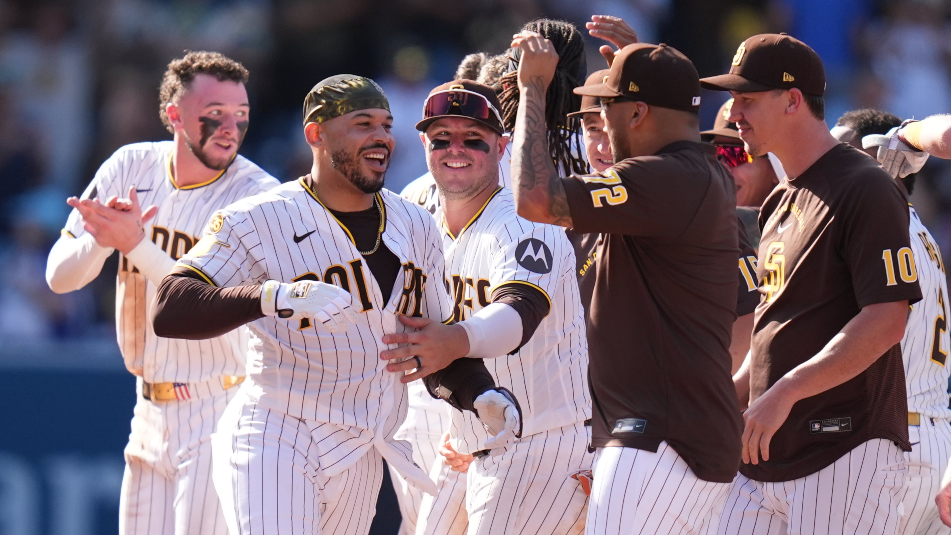 San Diego Padres' Luis Campusano, second from left, celebrates with teammates after hitting a walk off single to defeat the Brewers during the eleventh inning of a baseball game Wednesday, Aug. 12, 2026, in San Diego. (AP Photo/Gregory Bull)