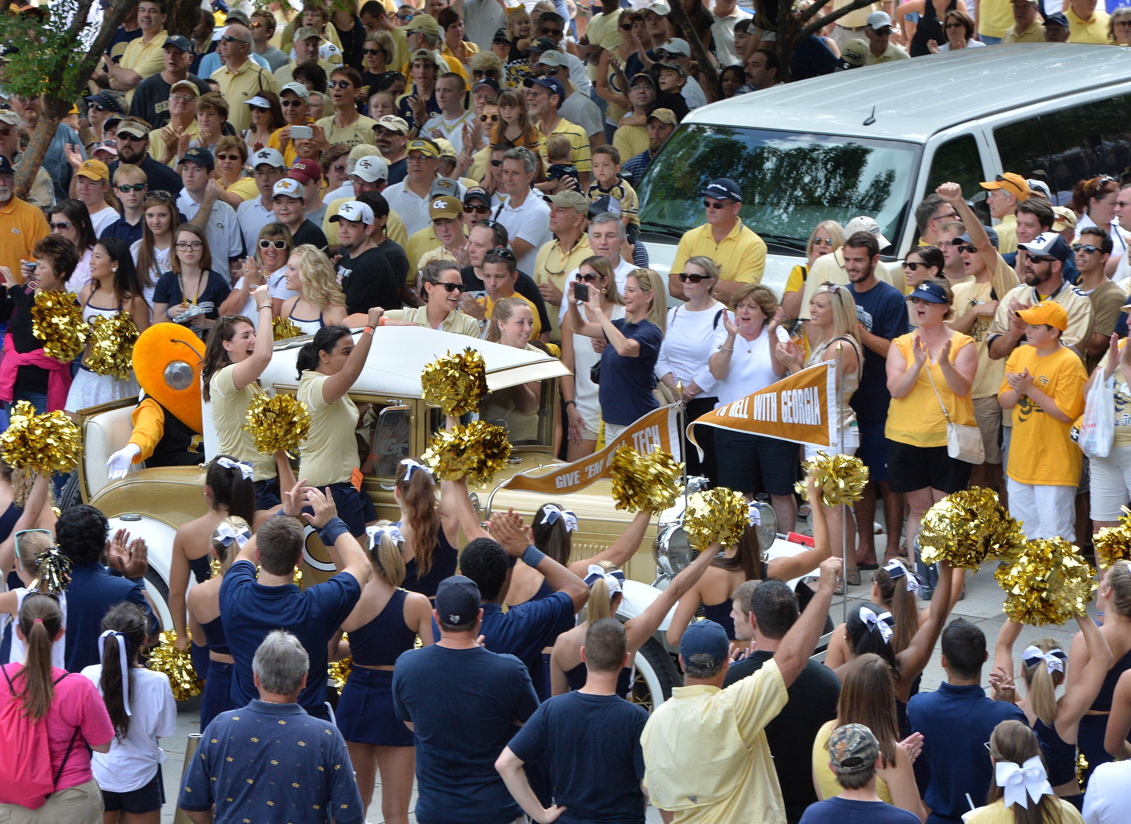 Georgia Tech's Ramblin' Wreck leads the band and cheerleaders through hundreds of fans down Yellow Jacket Alley before the start of the Georgia Tech season opener against the Wofford Terriers at Bobby Dodd Stadium on Saturday, August 30, 2014. HYOSUB SHIN / HSHIN@AJC.COM