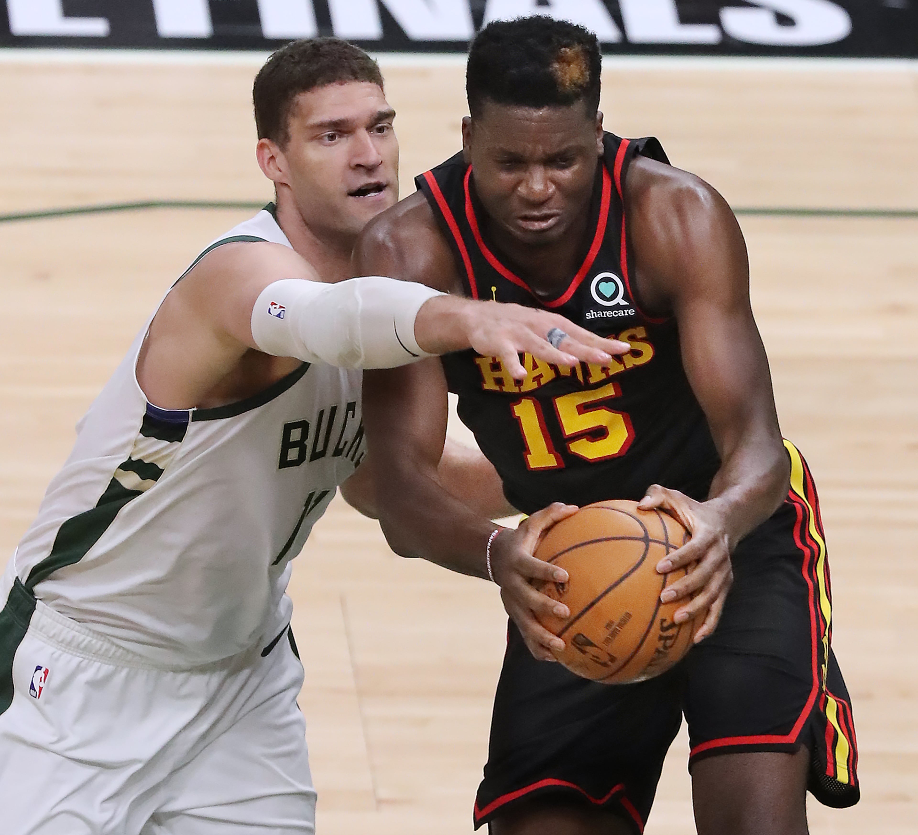Hawks center Clint Capela battles Milwaukee Bucks center Brook Lopez for a rebound during the second quarter. “Curtis Compton / Curtis.Compton@ajc.com”