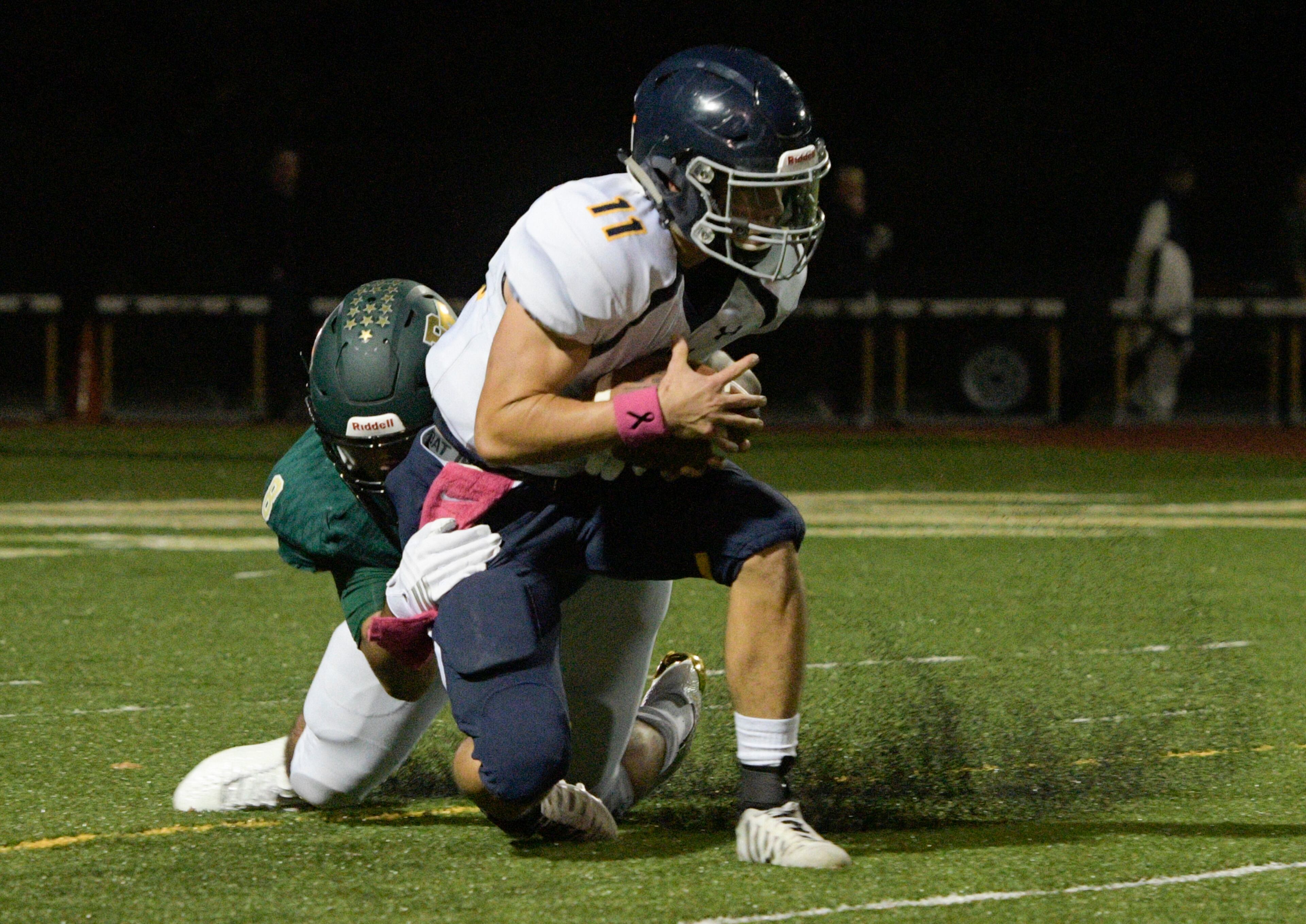 Marist QB Chase Abshier (11) is brought down by Blessed Trinity defender Jr Bivens during a high school football game, Friday, Oct. 20, 2017, in Roswell. (John Amis)