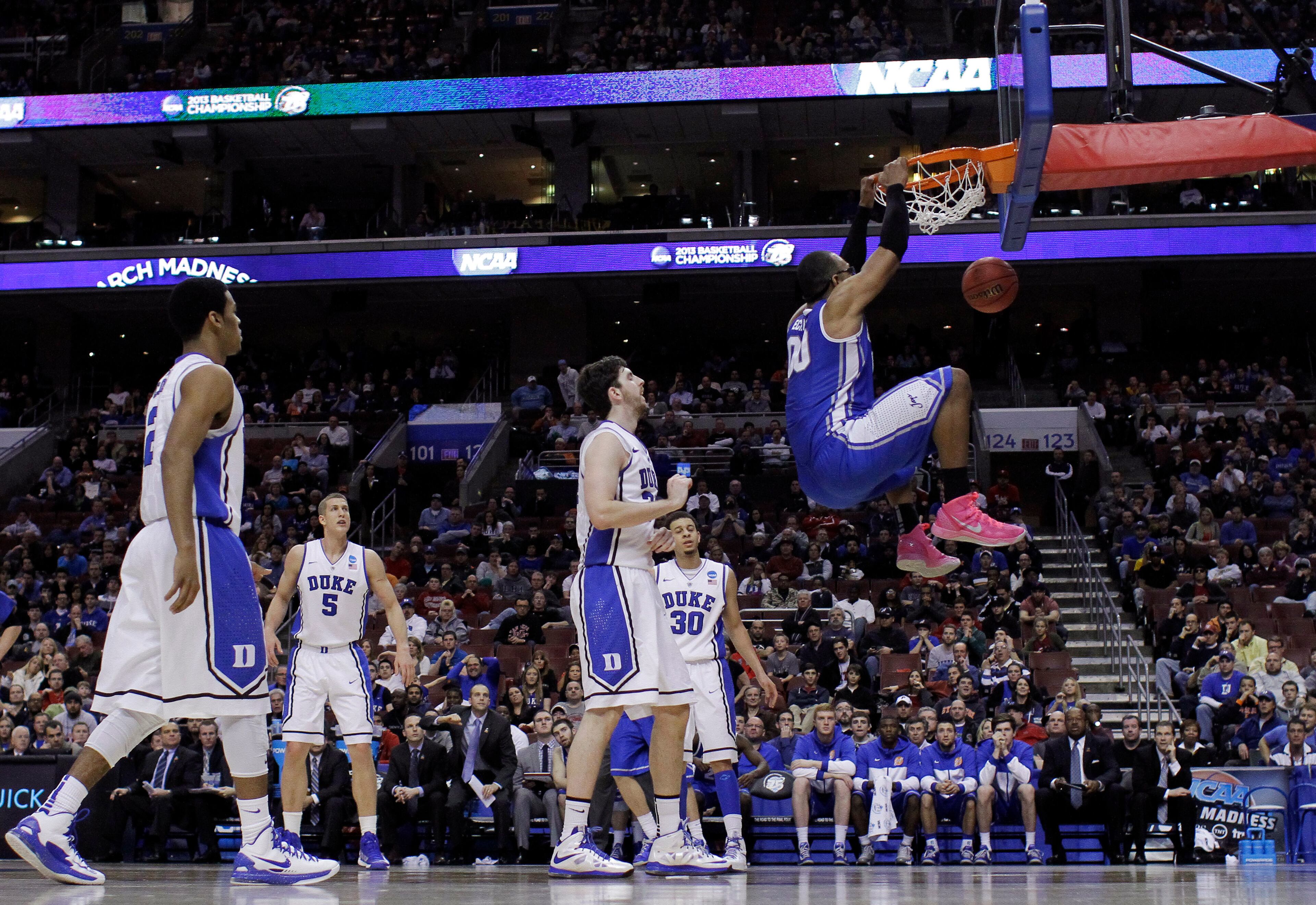 Creighton's Gregory Echenique, right, hangs on the rim after a dunk during the second half of a third-round game against Duke in the NCAA college basketball tournament, Sunday, March 24, 2013, in Philadelphia. Duke won 66-50. (AP Photo/Matt Slocum)