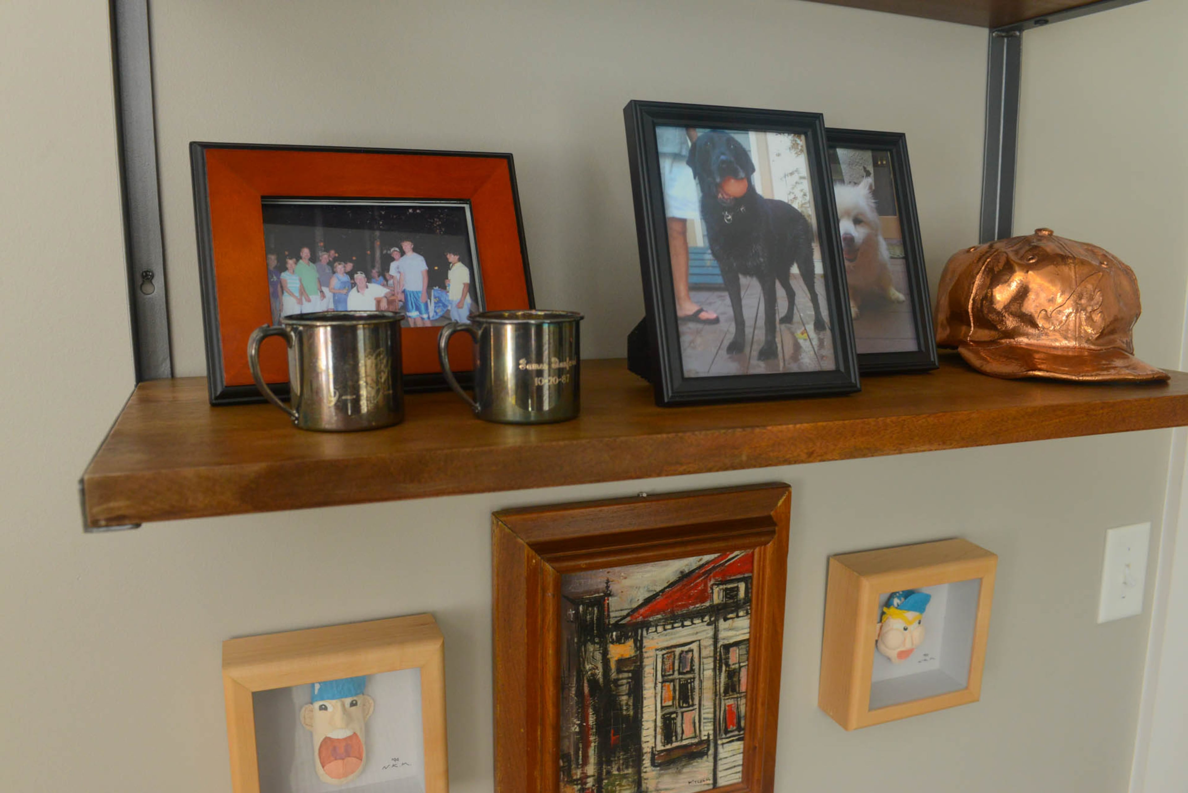 While Dee's two sons are now grown, her bedroom shelves hold mementos from their childhoods. The two silver cups are engraved with each son's name and birthdate, and the bronzed Atlanta Braves cap was worn and passed down from the older son to the younger son.