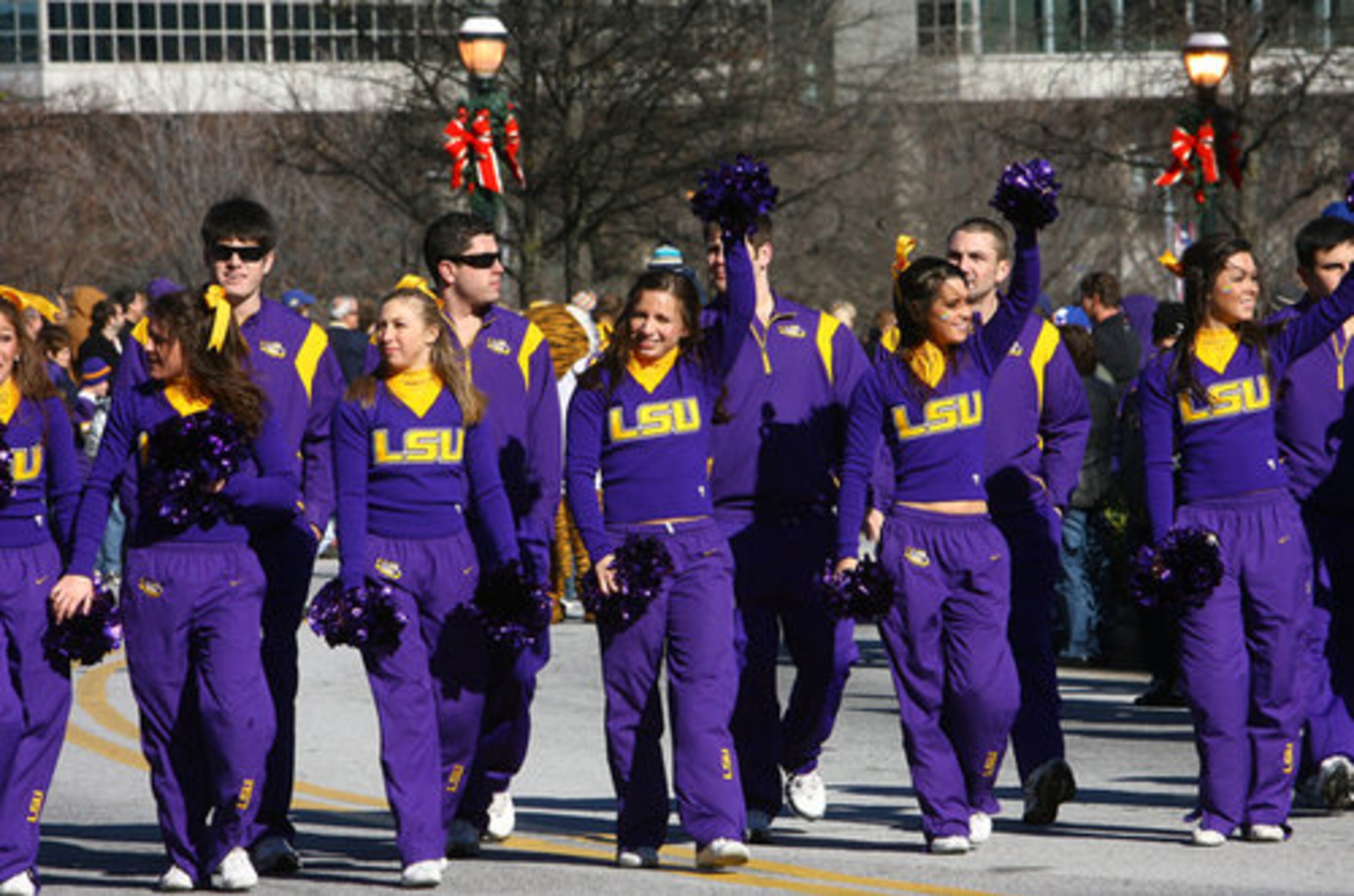 LSU cheerleaders march in front of the school's band.