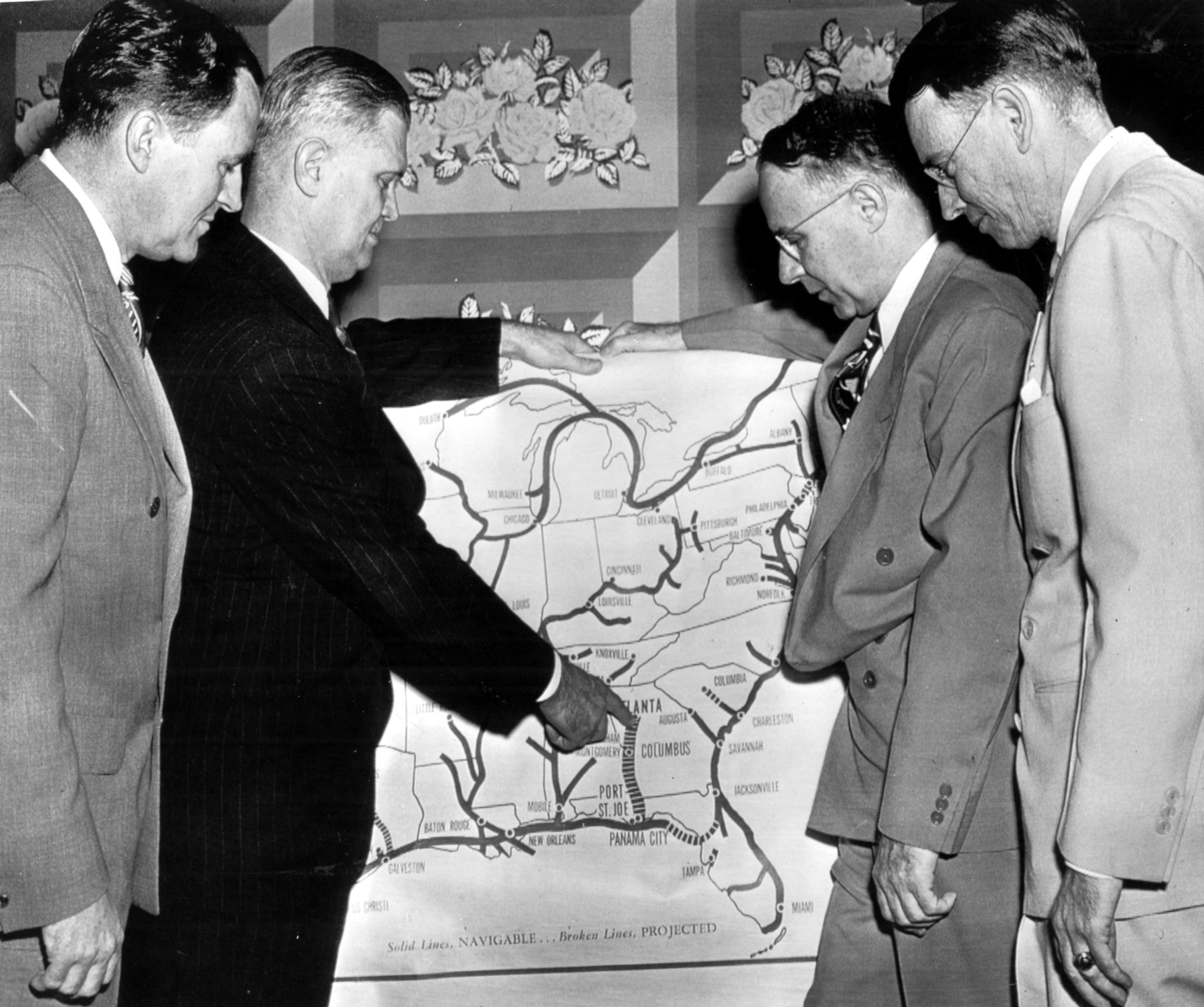 A group of Georgians use a map to discuss the possibilities of the proposed Buford Dam on the Chattahoochee River during a meeting in Washington in the late 1940s. Pictured are, from left: William Parker, of the Atlanta Freight Bureau; Rep. James C. Davis (D-Ga); Atlanta Mayor William B. Hartsfield, and Julius McCurdy, Georgia state legislator from DeKalb County. (late 1940s)