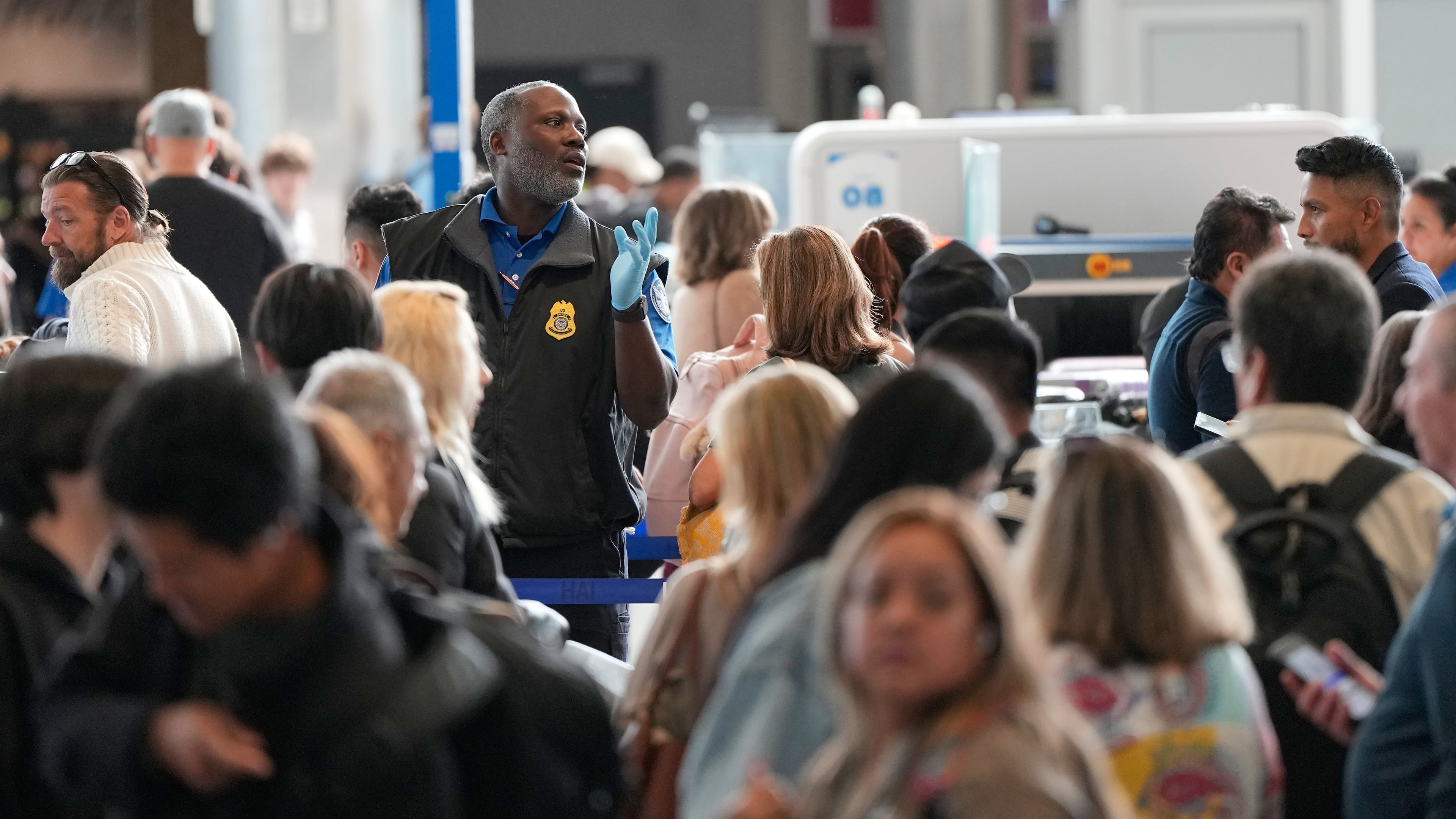 Passengers are directed through a security checkpoint line at George Bush Intercontinental Airport Thursday, March 19, 2026, in Houston. (AP Photo/David J. Phillip)