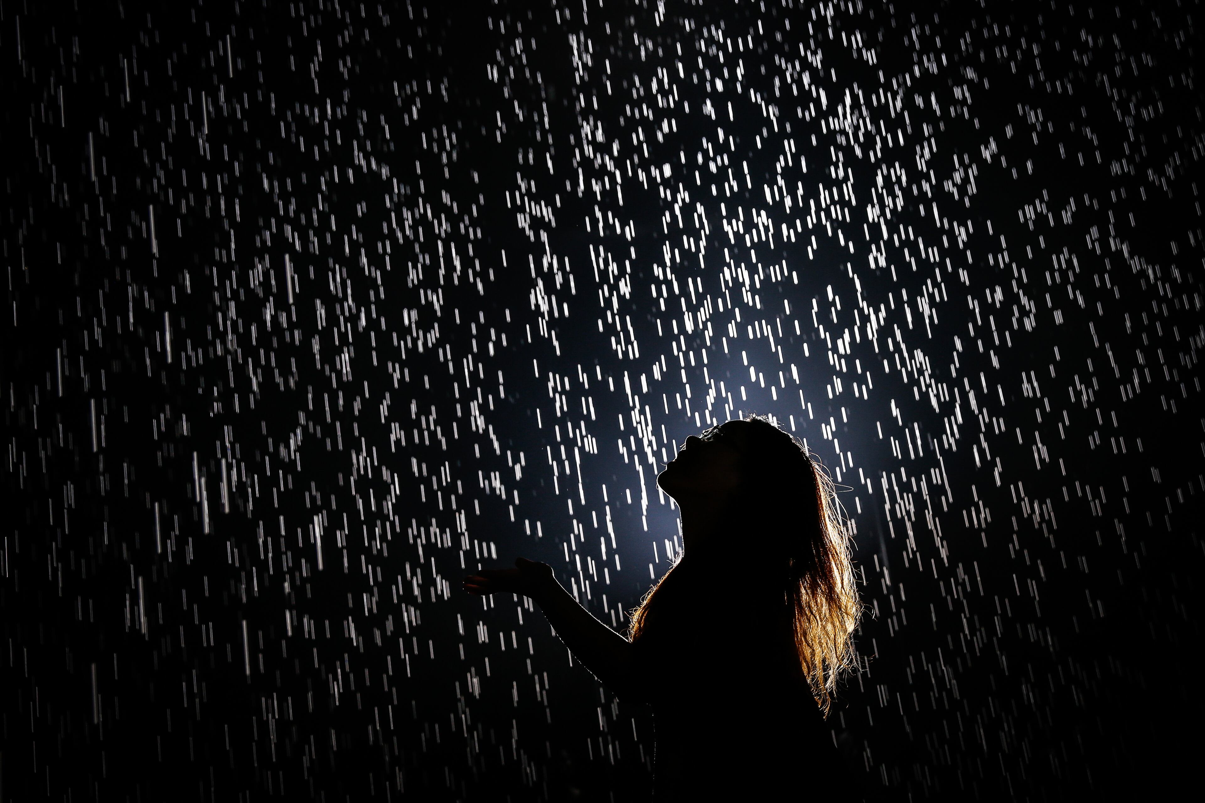 A visitor walks through and experiences "Rain Room" at Shanghai Yuz Museum on August 31, 2105 in Shanghai, China.