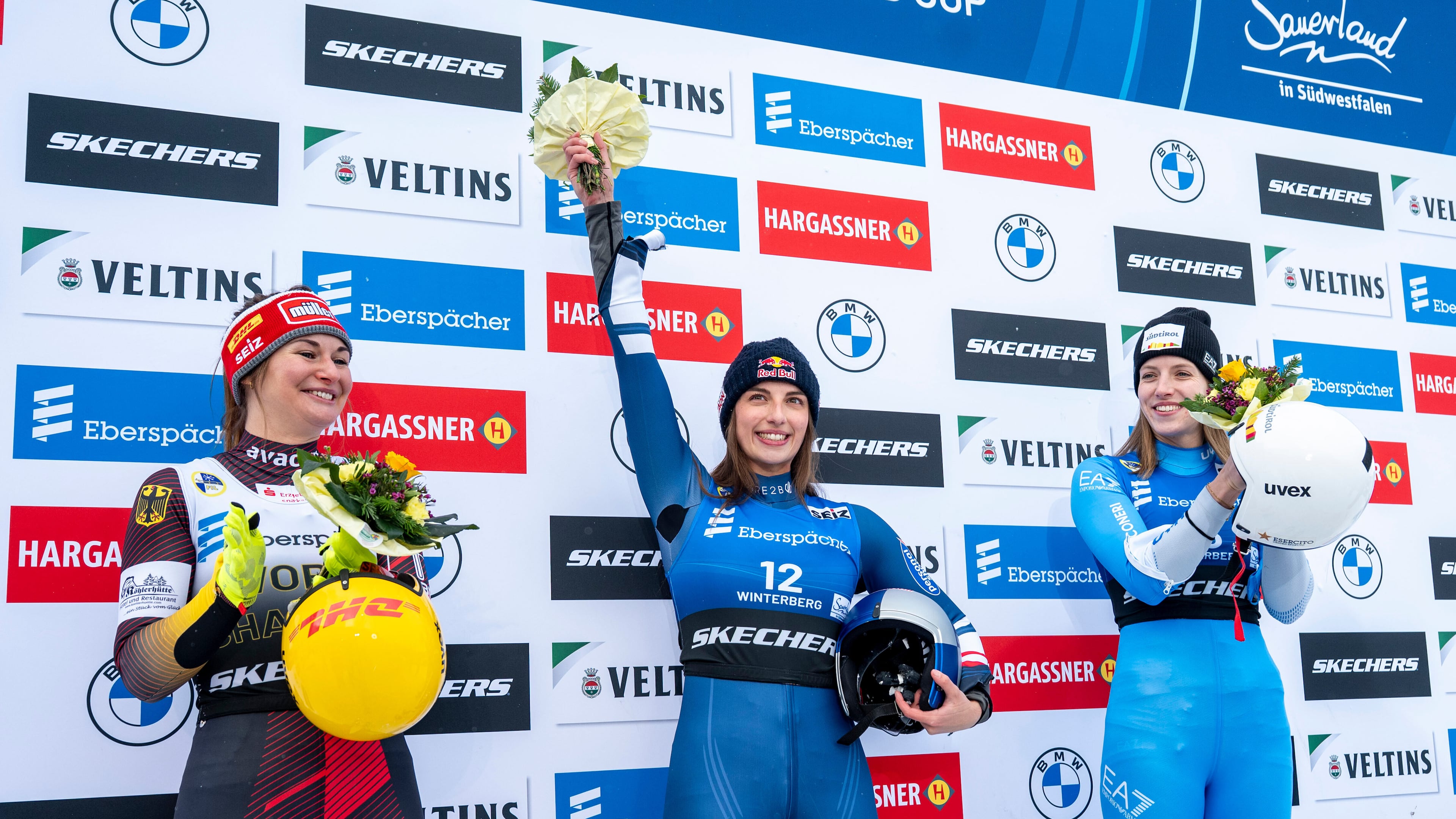 Runner-up Julia Taubitz, of Germany, from left, winner Hannah Prock, of Austria, and third-placed Verena Hofer, of Italy, celebrate on the podium following the Luge Women World Cup, single-seater, 2nd run in Winterberg, Germany, Saturday, Jan. 10, 2026. (David Inderlied/dpa via AP)