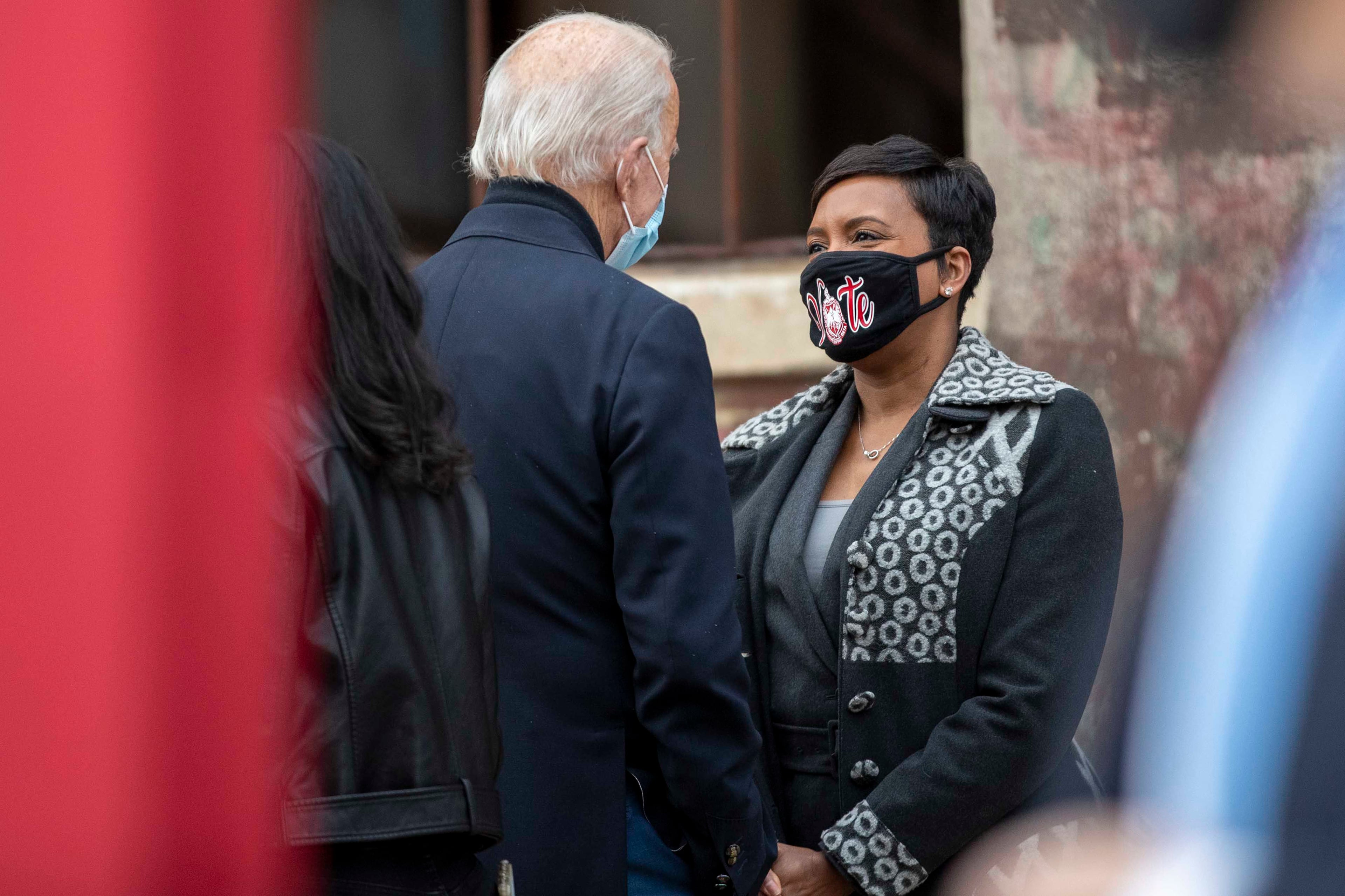 Atlanta Mayor Keisha Lance Bottoms has a conversation with then President-Elect Joe Biden following his remarks during a "Get Ready to Vote" rally for Georgia Democrat U.S. Senator candidates Rev. Raphael Warnock and Jon Ossoff at Pratt-Pullman Yard in Atlanta's Kirkwood neighborhood, on Dec. 15, 2020. (Alyssa Pointer/AJC/TNS)