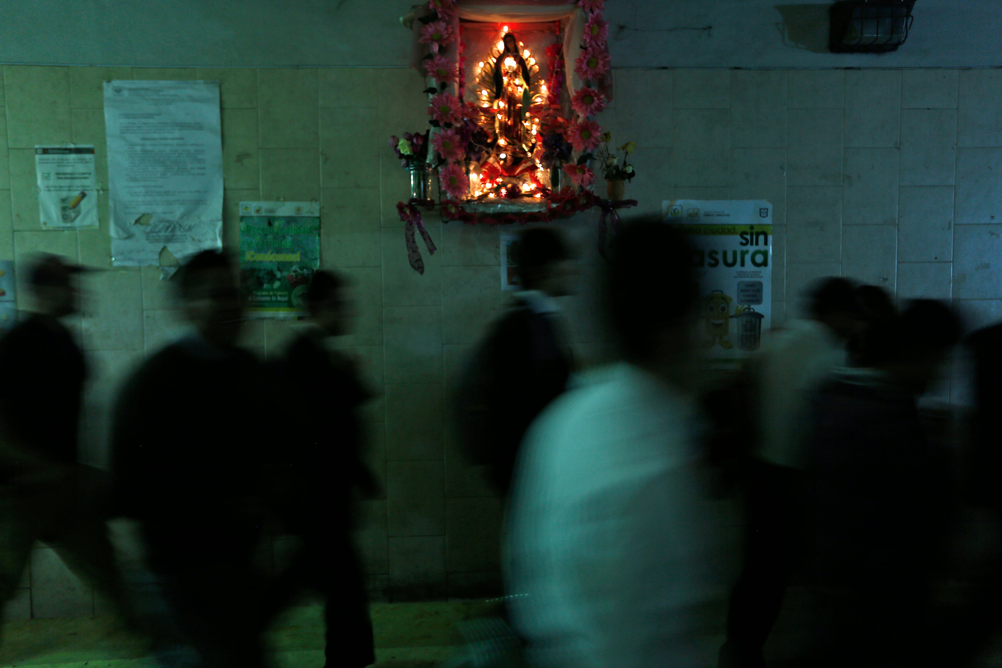 In this Sept. 17, 2014, commuters cross Reforma Avenue through an underground tunnel decorated with an altar of Our Lady of Guadalupe in Mexico City. (AP Photo/Moises Castillo)
