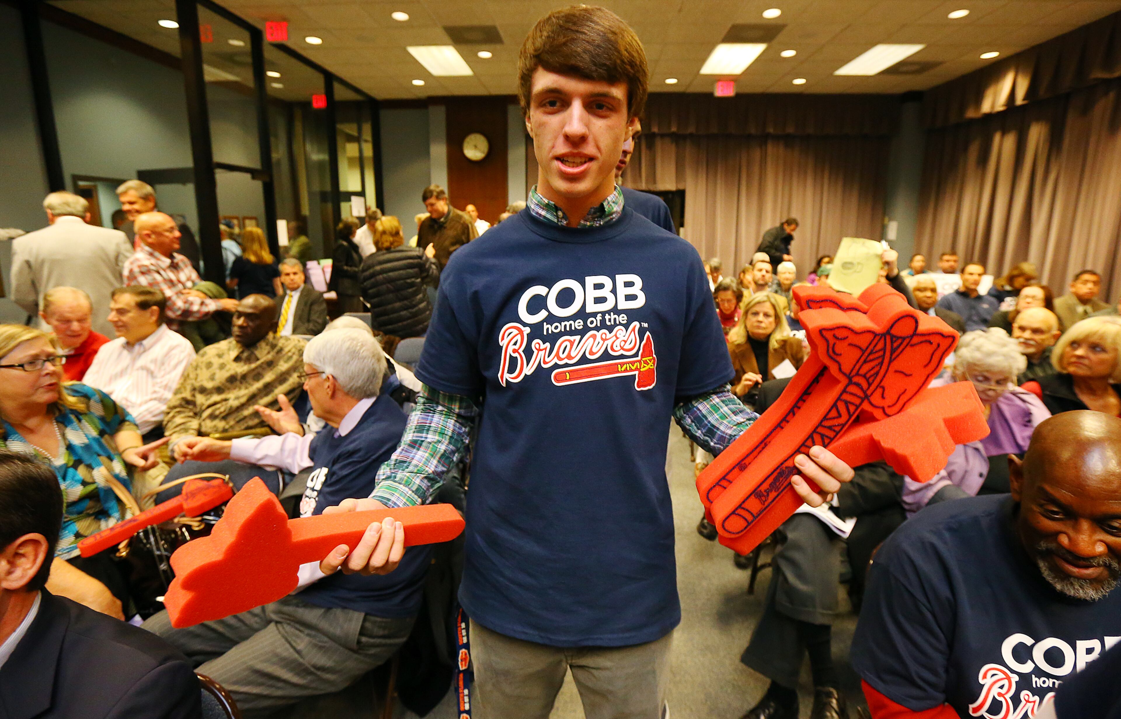Stadium supporter Joshua Loud hands out tomahawks to attendees before the Cobb County Board of Commissioners vote on the Braves stadium.