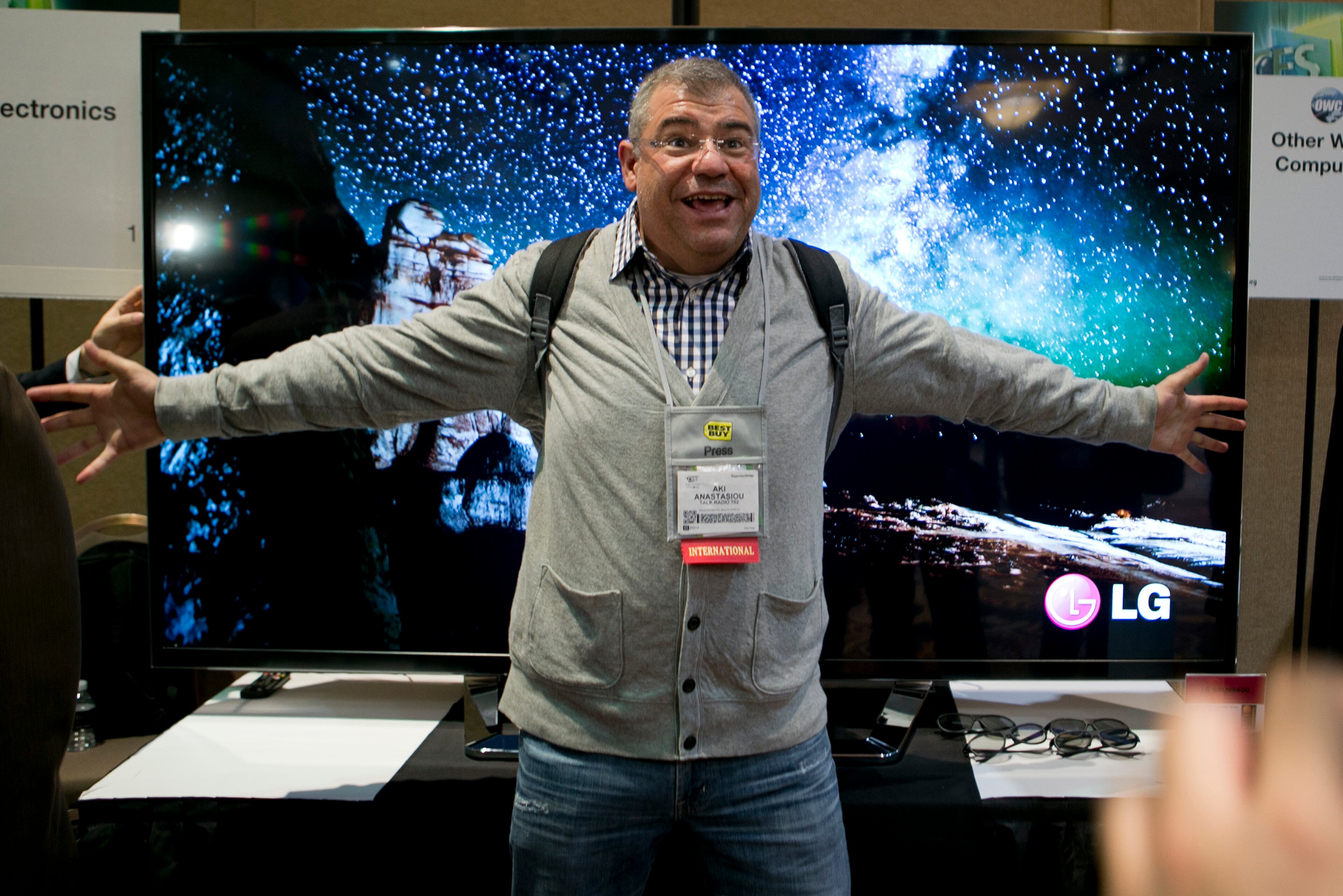 Aki Anastasiou stands in front of a LG Electronics Inc. Ultra HD Cinema 3D television during a press event prior to the 2013 International Consumer Electronics Show in Las Vegas, Nevada, U.S., on Sunday, Jan. 6, 2012. The 2013 CES trade show, which runs until Jan. 11, is the world's largest annual innovation event.