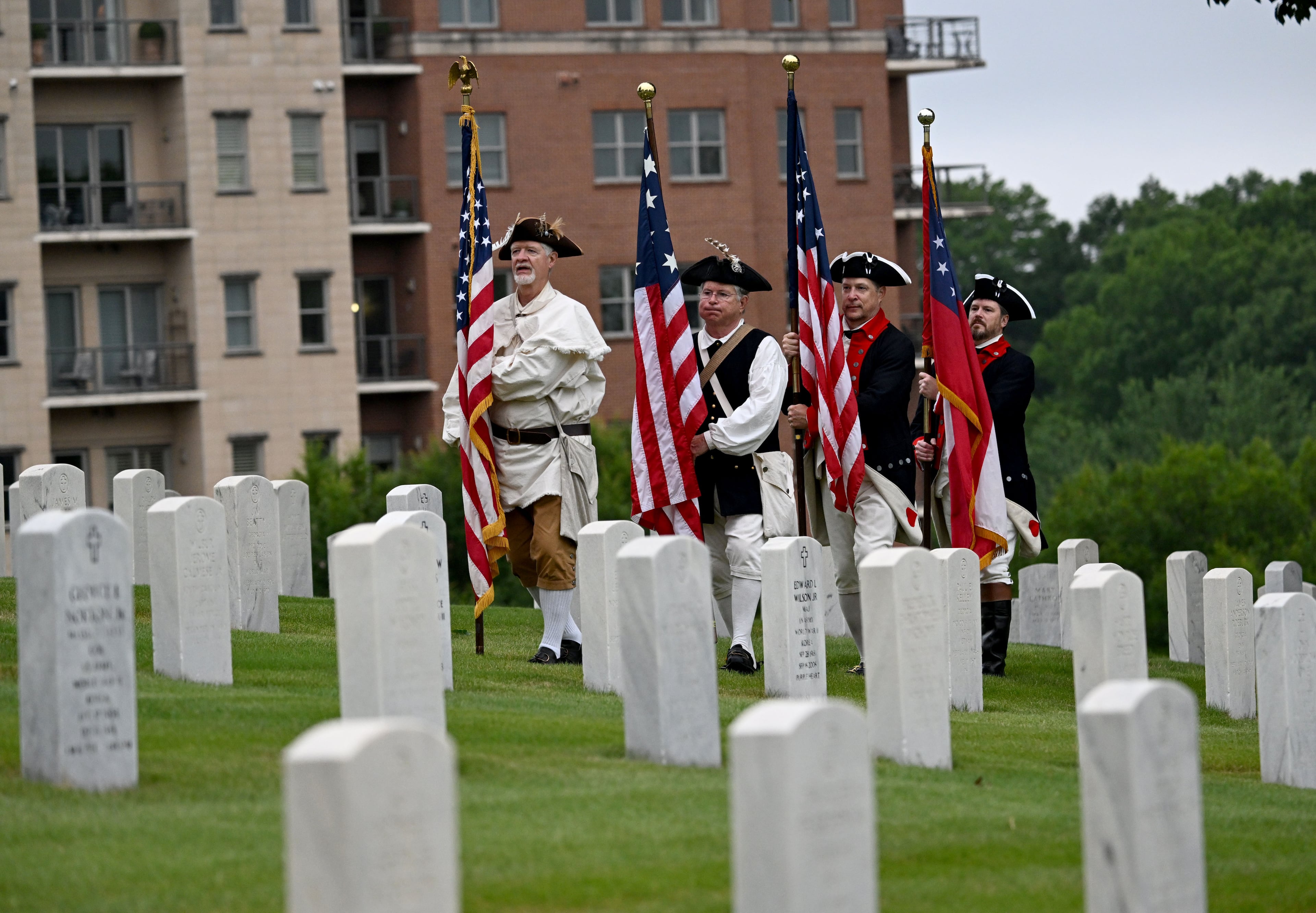 The Presentation of Colors starts the Memorial Day Flag Placement event at Marietta National Cemetery on Saturday, May 23, 2026, in Marietta. Scouting groups in the community place more than 18,000 U.S. veteran grave flags at Marietta National Cemetery each year on the Saturday before Memorial Day, helping prepare for Monday’s ceremony. The long-running service project—organized with the National Memorial Day Association of Georgia—also gives youth and adults an opportunity to honor fallen service members and learn about their sacrifices and the area’s history. (Hyosub Shin/AJC)