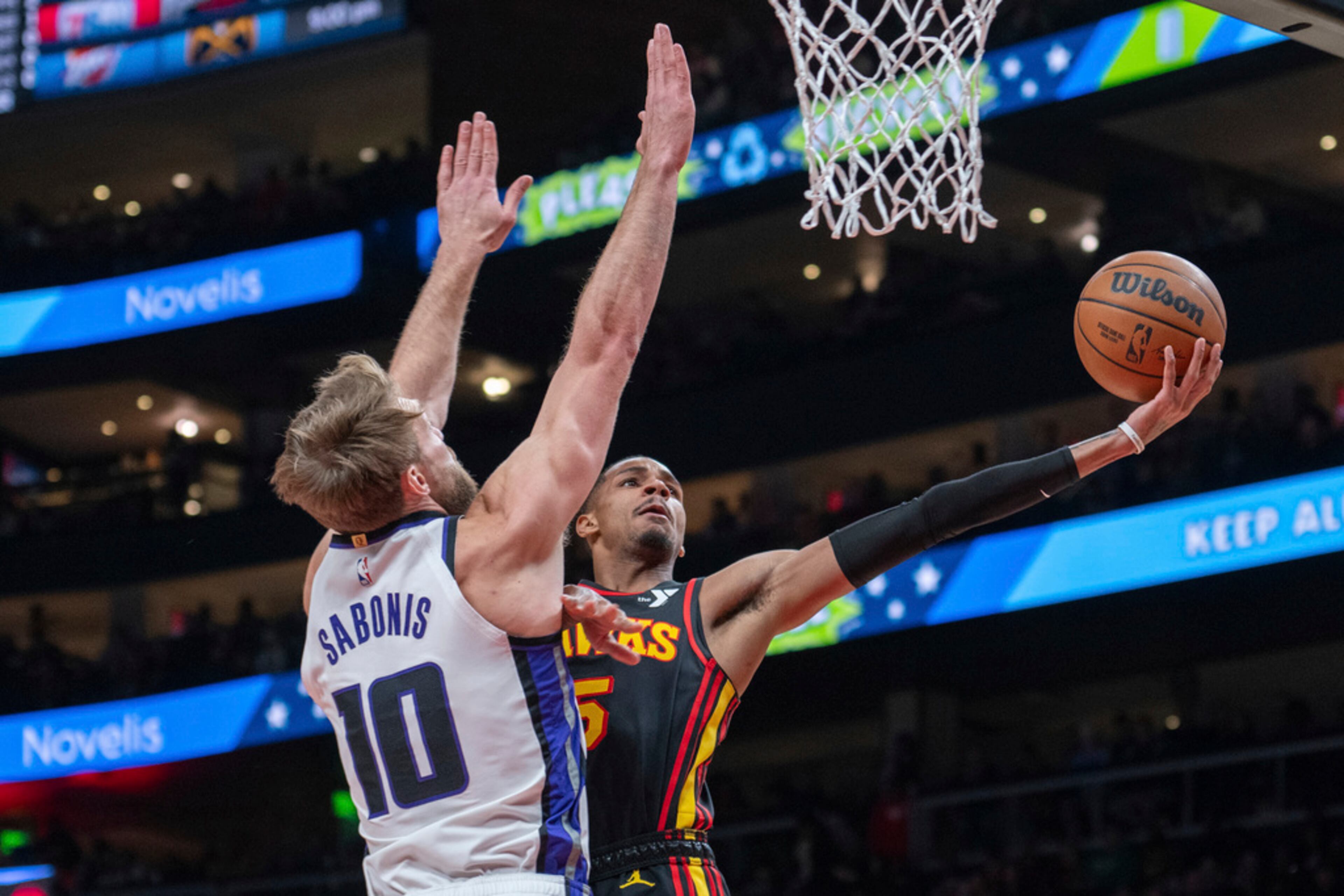 Atlanta Hawks guard Dejounte Murray (5) scores against Sacramento Kings forward Domantas Sabonis (10) during the first half of an NBA basketball game Friday, Dec 29, 2023, in Atlanta. (AP Photo/Hakim Wright Sr.)