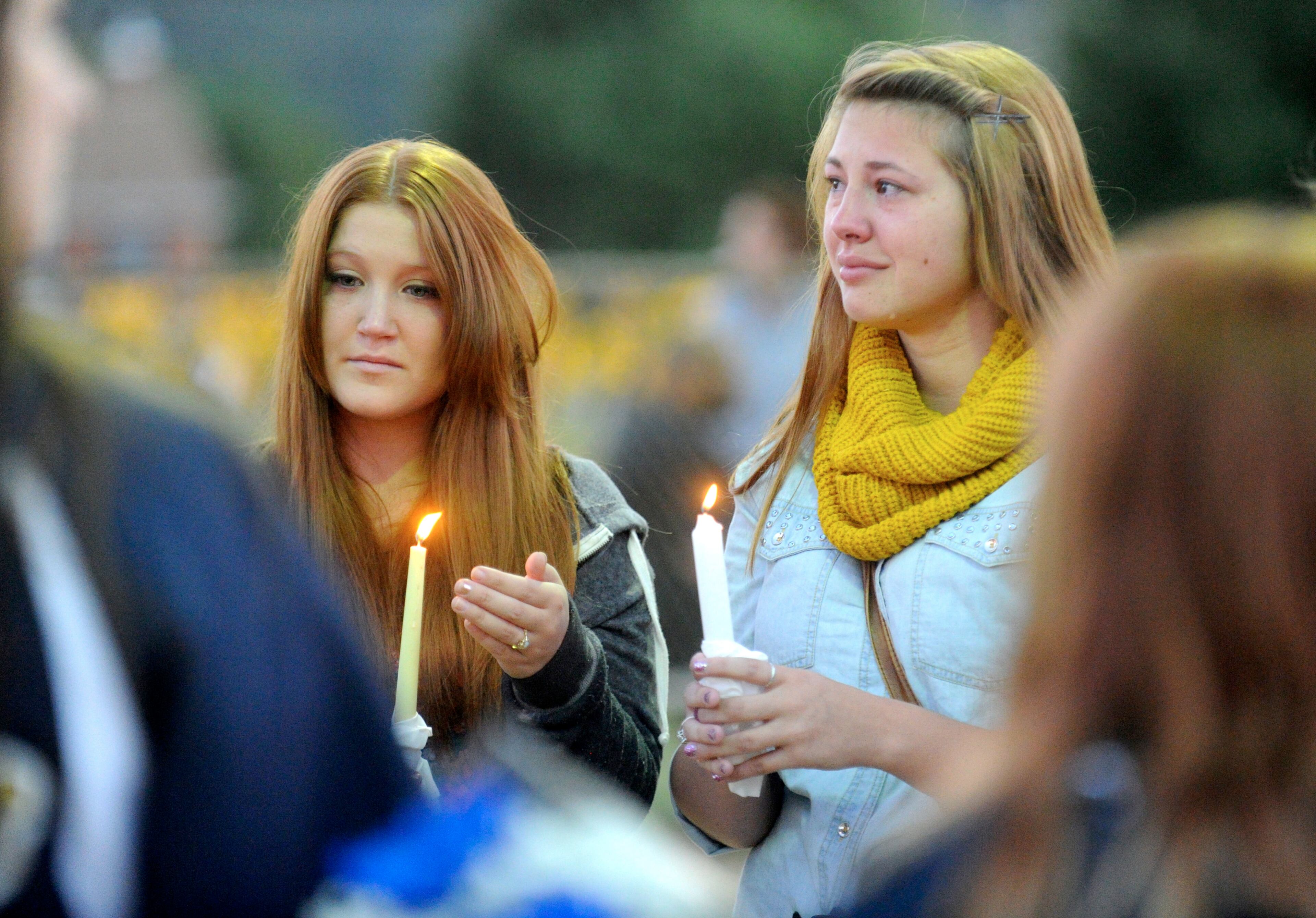 Megan Ridgell, left, and Colette Turner take part in a candlelight vigil in honor of Richard Michael Ridgell, Megan's father, at Jaycee Park in Westminster, Md. Tuesday, Sept. 17, 2013. Ridgell was killed in Monday's shooting at the Navy Yard in Washington. (AP Photo/Carroll County Times, Dave Munch)