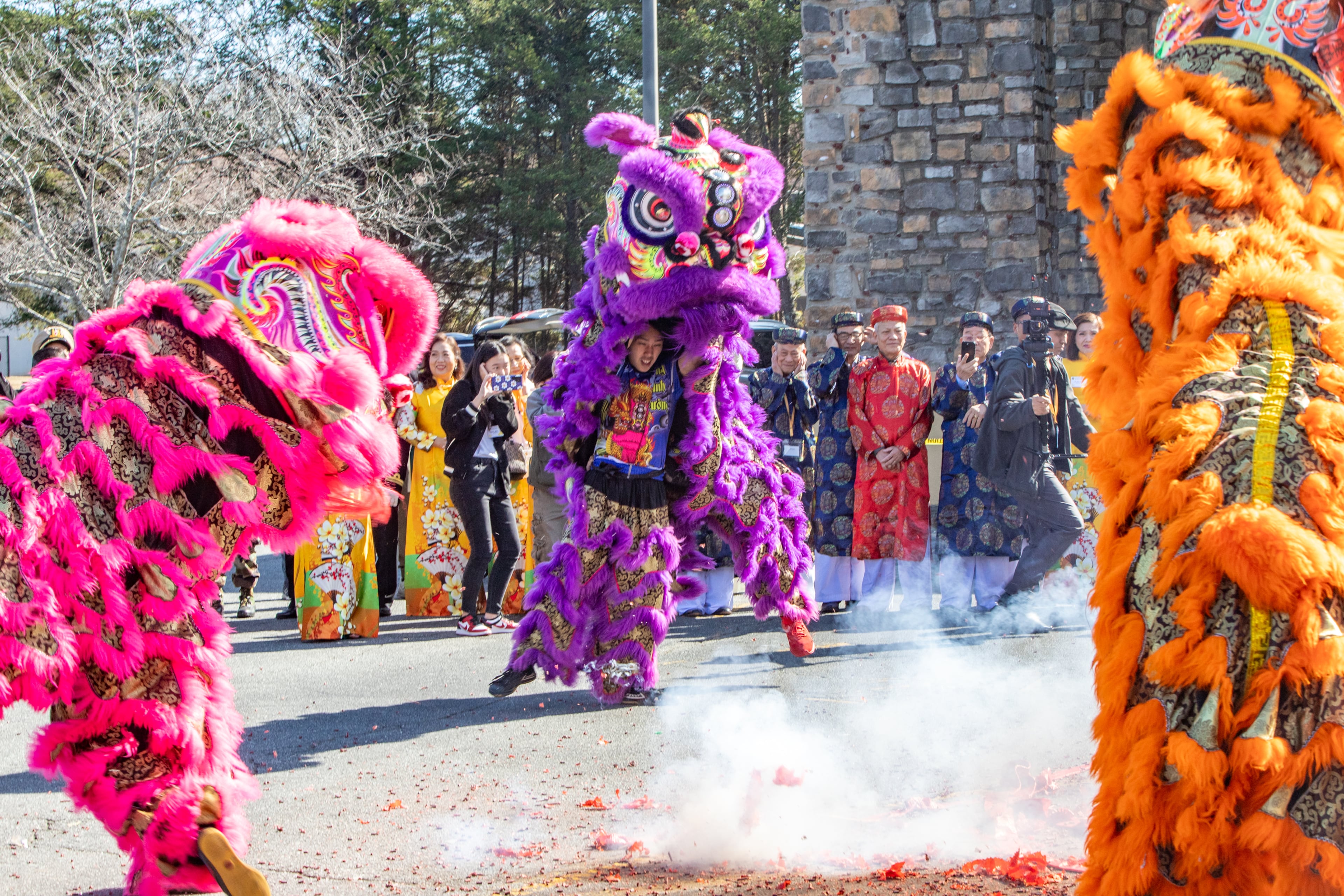Lion dancers, including Brandon Dang, in purple, dance around firecrackers as festivities begin Saturday, Feb 3, 2024. The Vietnamese American Community of Georgia hosts a Lunar New Year celebration at Plaza Las Americas in Lilburn on where dragon and lion dancing begins the weekend. The celebration continues on Sunday and includes traditional food, music and cultural festivities. (Jenni Girtman for The Atlanta Journal-Constitution)