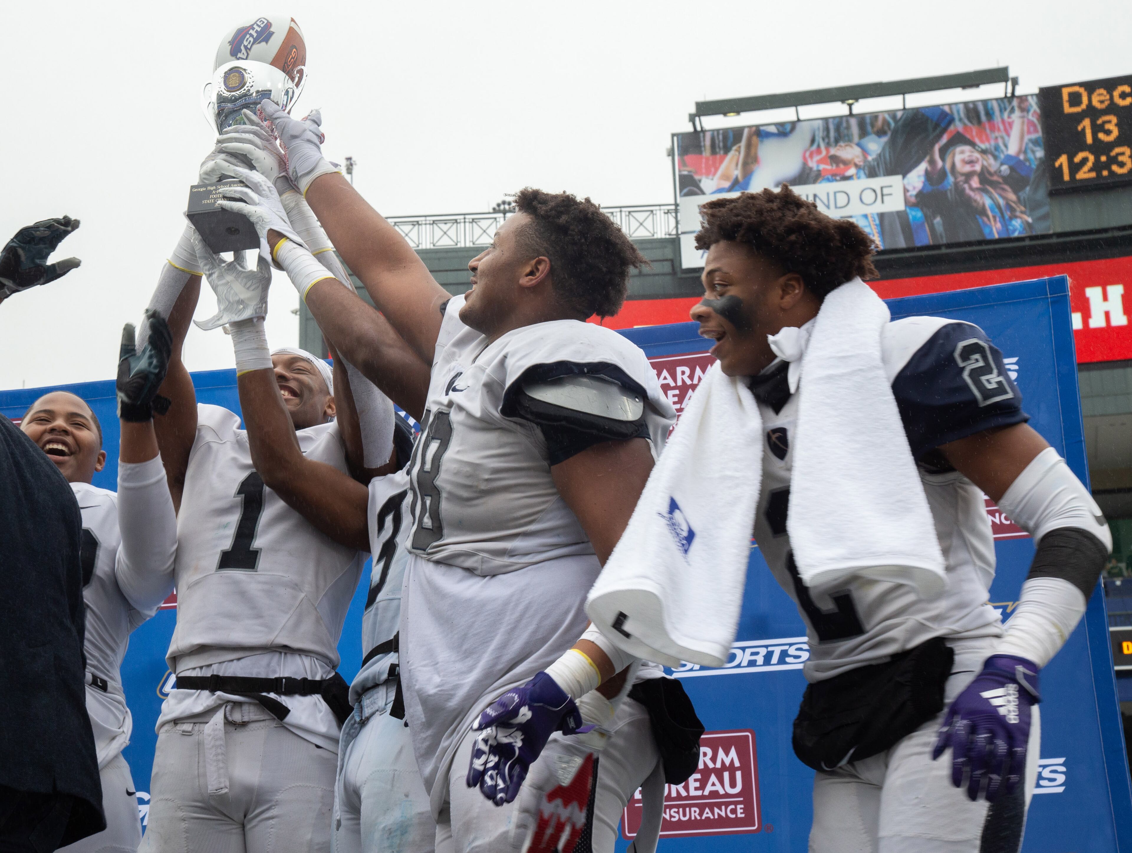Eagle's Landing Christian Academy players hold up the trophy after beating Wesleyan High School during the Class A private state title football championship game against Wesleyan HighSschool at Georgia State Stadium Friday, December 13, 2019. STEVE SCHAEFER / SPECIAL TO THE AJC