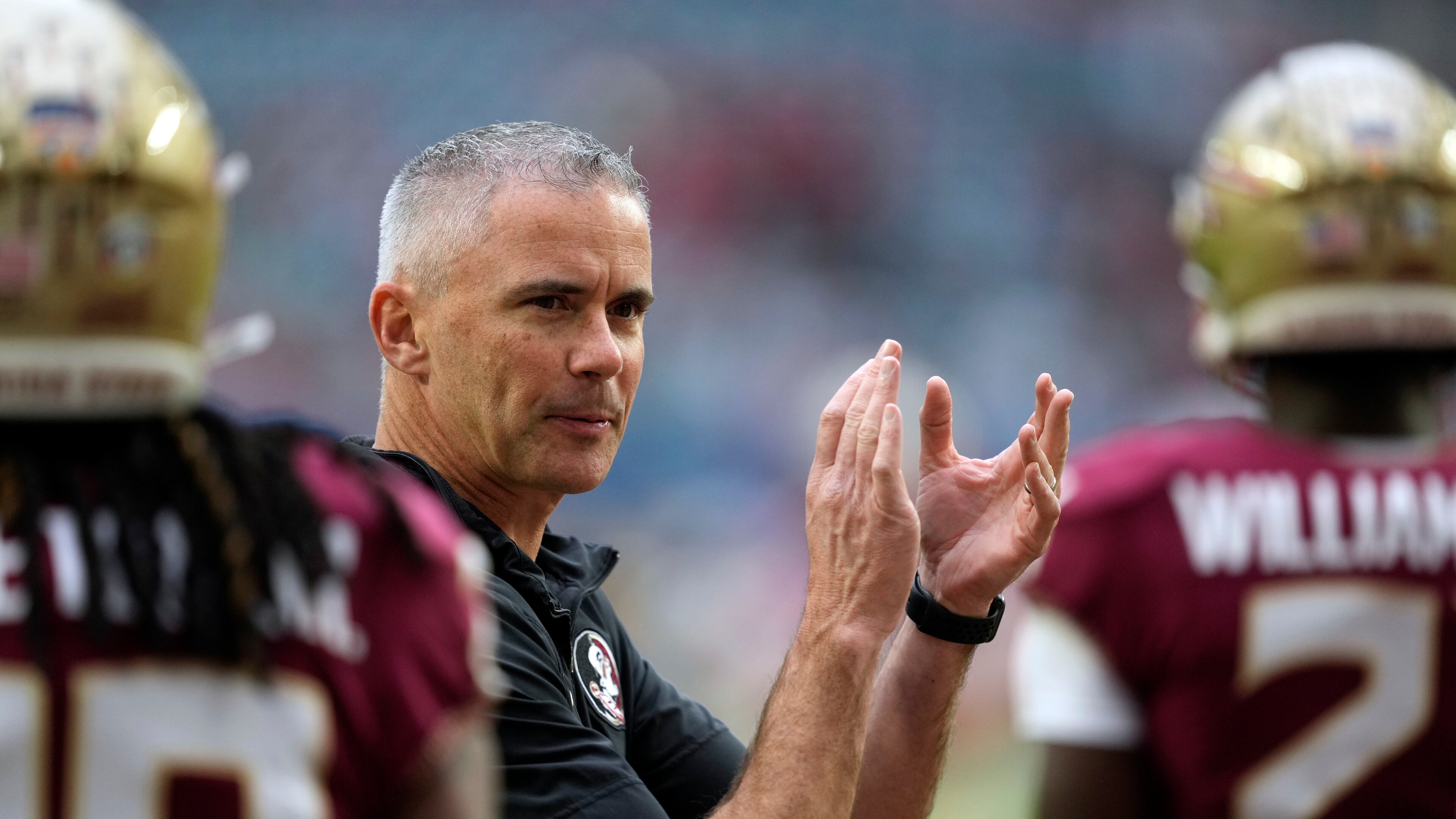 FILE - Florida State head coach Mike Norvell claps as his players warm up for the Orange Bowl NCAA college football game against Georgia, Saturday, Dec. 30, 2023, in Miami Gardens, Fla. Norvell, like most every other team in the Atlantic Coast Conference, has spent the spring handling change. He hopes it can lead to another league title and a spot in the 12-team College Football Playoff. (AP Photo/Rebecca Blackwell, File)