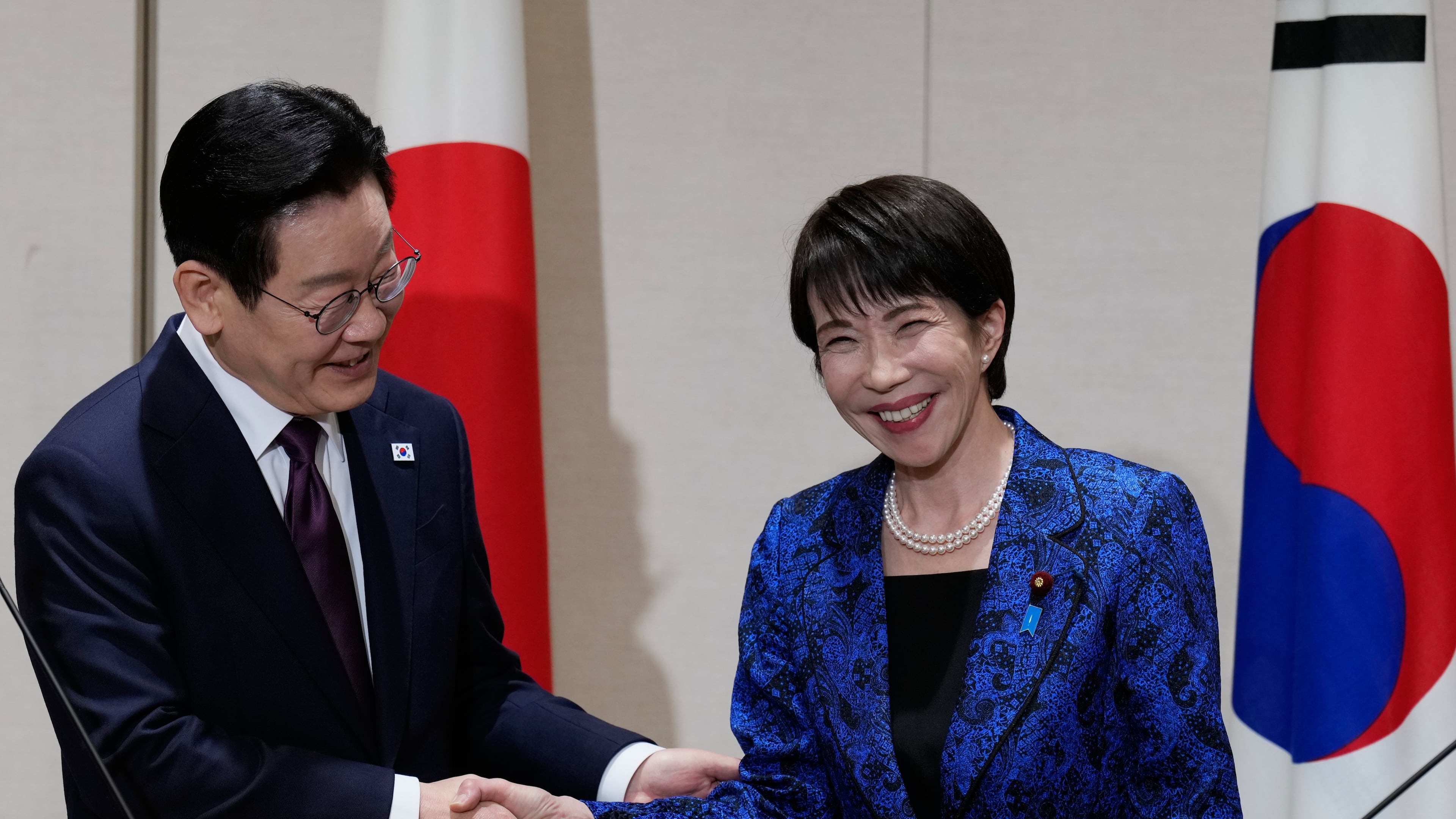 Japanese Prime Minister Sanae Takaichi, right, and South Korean President Lee Jae Myung pose for a photo as they shake hands during their joint news conference after their talk in Nara, western Japan, Tuesday, Jan. 13, 2026. (AP Photo/Eugene Hoshiko, Pool)