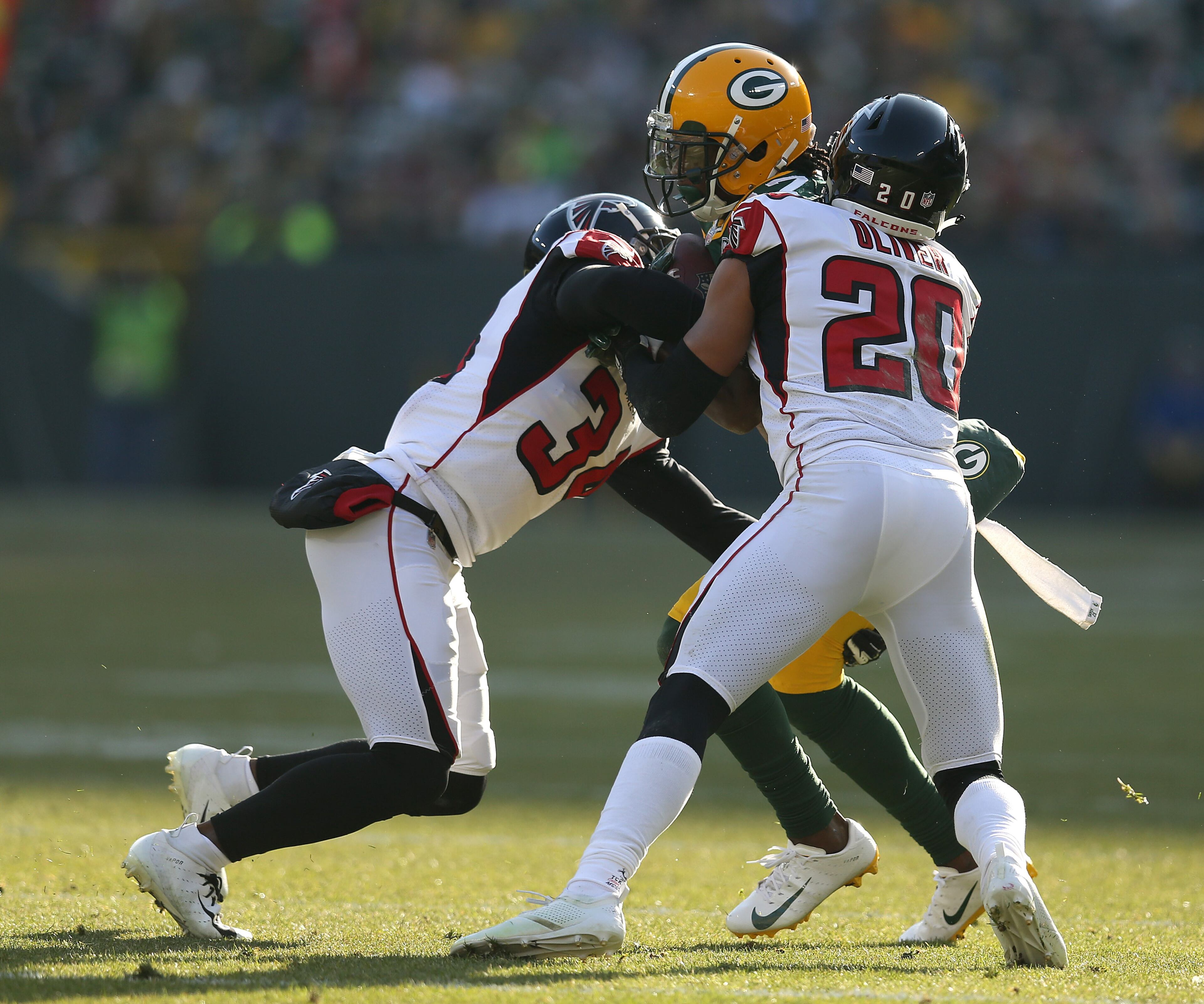 GREEN BAY, WISCONSIN - DECEMBER 09: Davante Adams #17 of the Green Bay Packers is tackled by Brian Poole #34 of the Atlanta Falcons and Isaiah Oliver #20 during the first half of a game at Lambeau Field on December 09, 2018 in Green Bay, Wisconsin. (Photo by Dylan Buell/Getty Images)