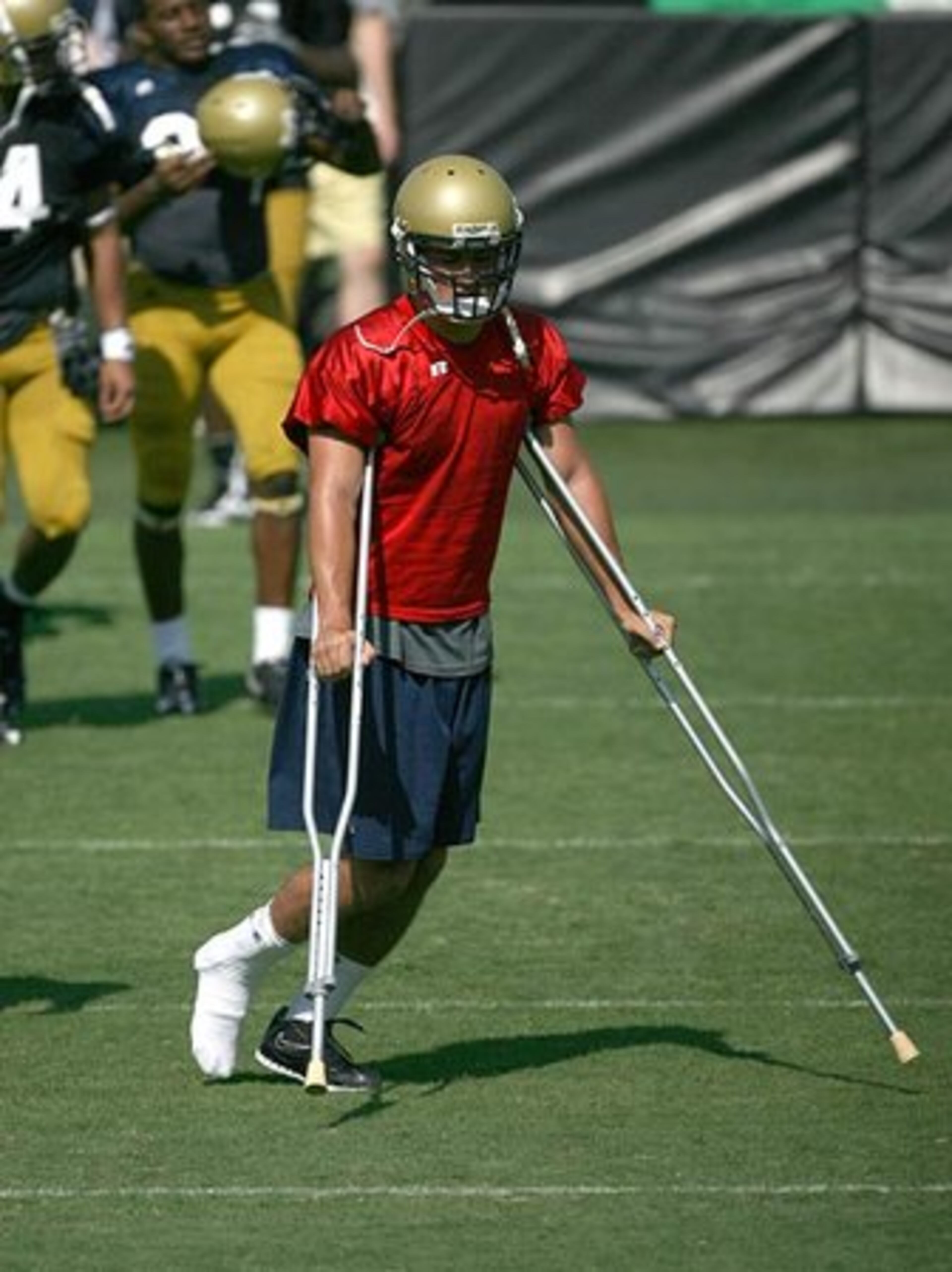 Freshman quarterback Jordan Luallen uses crutches to move around during morning football practice Monday. He was injured during practice on Saturday.