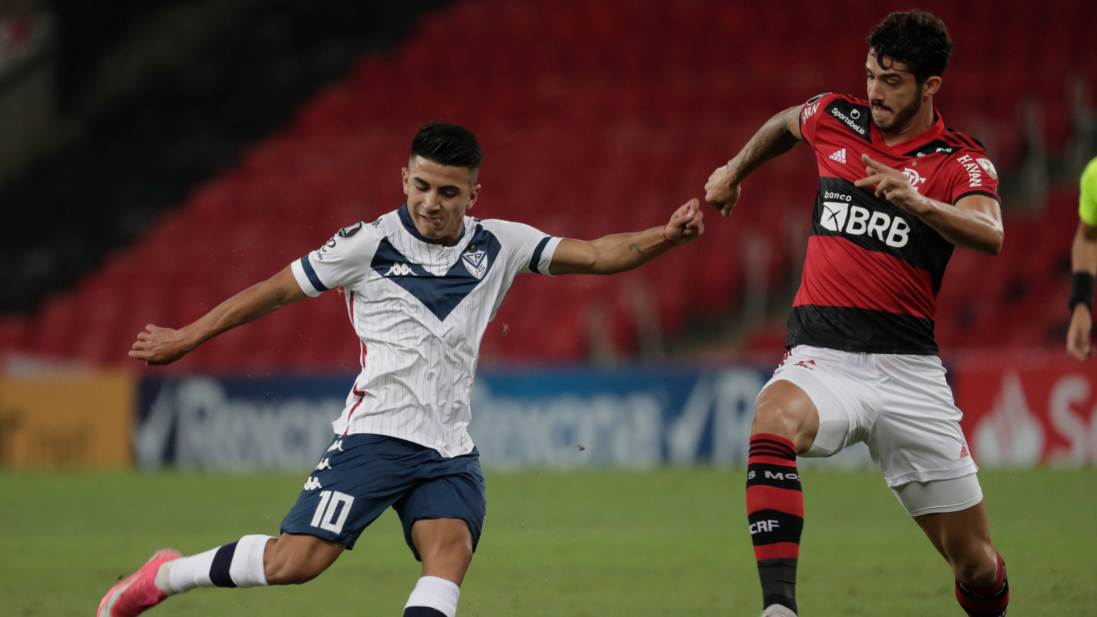 Thiago Almada of Argentina's Velez Sarsfield (left) and Gustavo Henrique of Brazil's Flamengo battle for the ball during a Copa Libertadores soccer match Thursday, May 27, 2021, in Rio de Janeiro, Brazil. (Antonio Lacerda/AP)