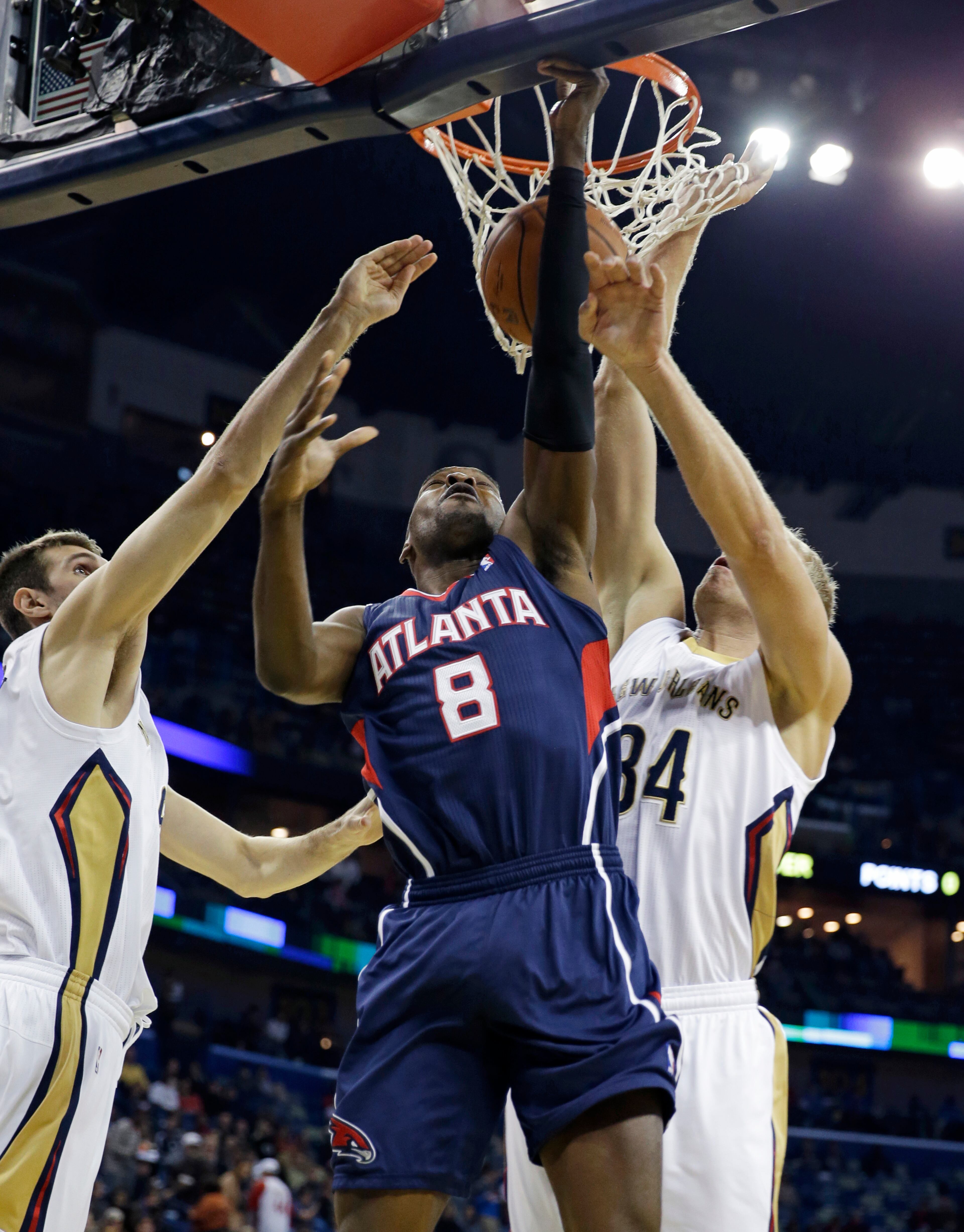 Atlanta Hawks point guard Shelvin Mack (8) is blocked as he goes to the basket between New Orleans Pelicans center Greg Stiemsma (34) and center Jeff Withey, left, in the first half of an NBA basketball game in New Orleans, Wednesday, Feb. 5, 2014. The Pelicans won, 105-100. (AP Photo/Gerald Herbert)