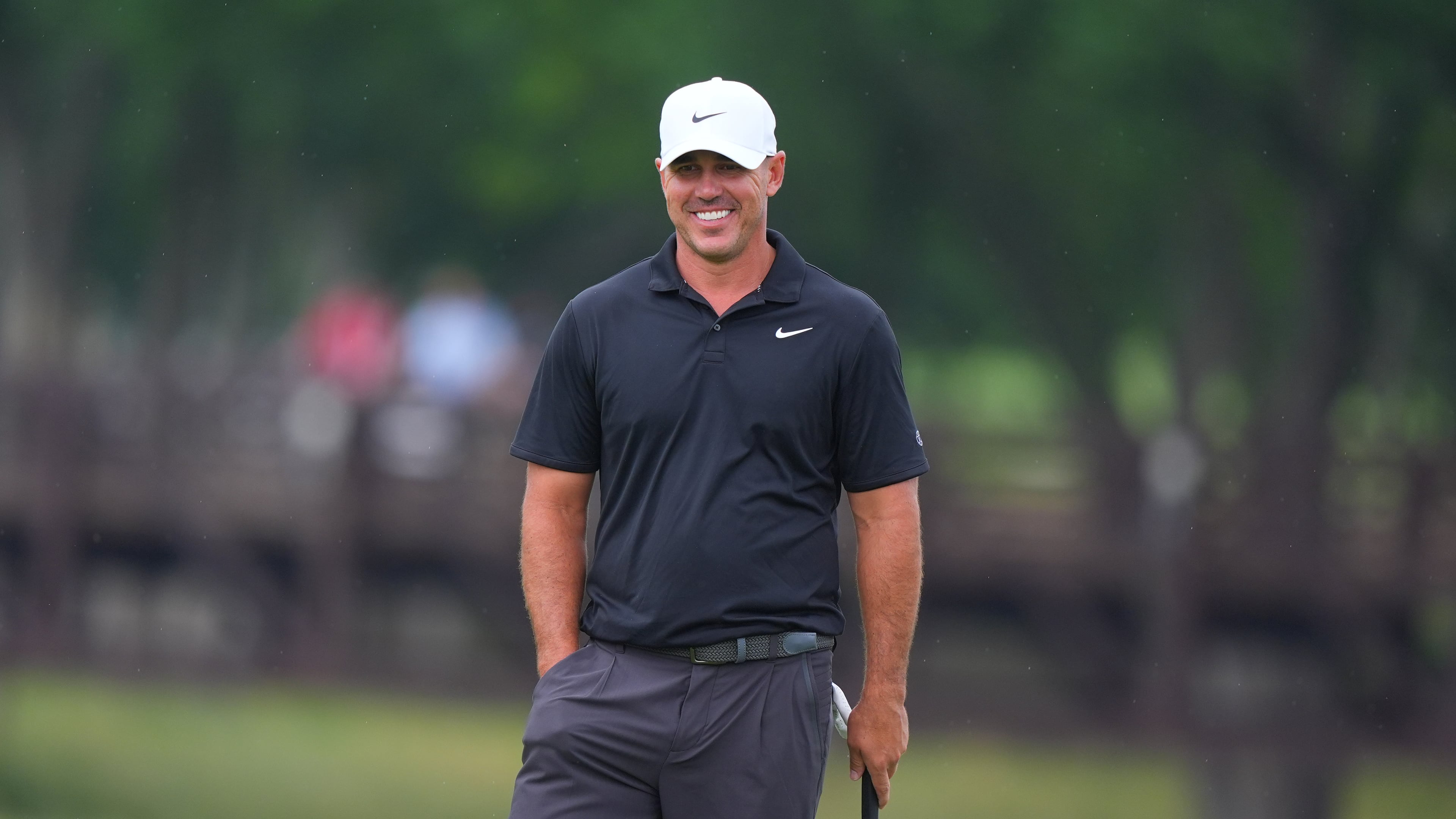 Brooks Koepka smiles while standing on the ninth green during of the first round of the Byron Nelson golf tournament in McKinney, Texas, Thursday, May 21, 2026. (AP Photo/LM Otero)