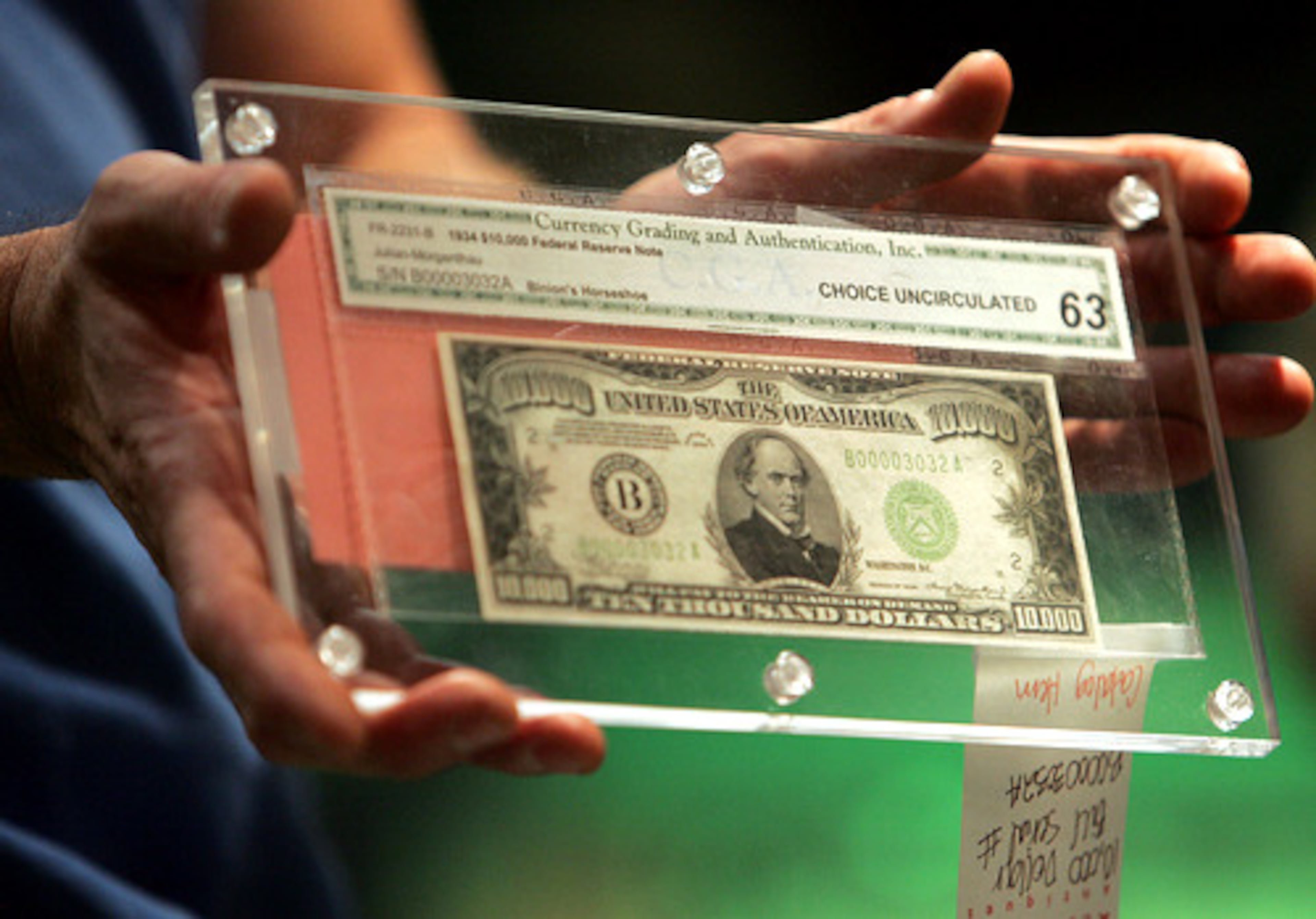 An auctioneer displays an authentic $10,000 bill at the blow-out Red Baron's auction that clears out the store. The store has been around for more than 30 years. Three times a year, the owners auction everything off in one hectic weekend.