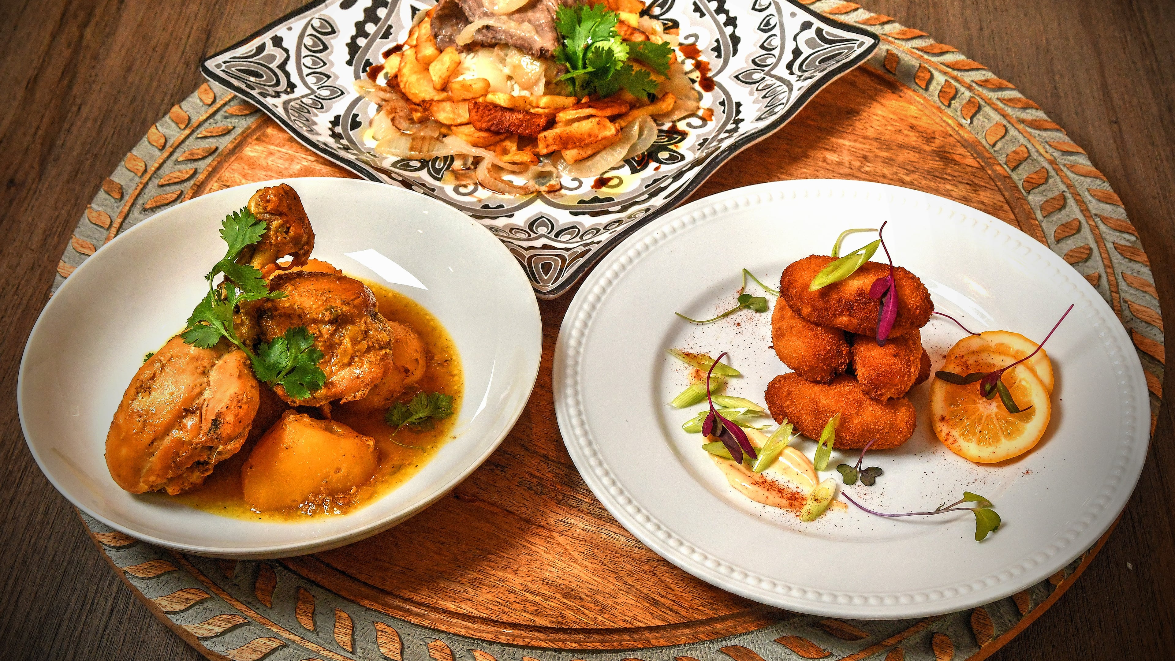 Clockwise from top: Bistec de Palomilla and French Fries, Serrano Ham and Bechamel Croquetas, and Fricassee de Pollo con Papas (Chicken Fricassee with Potatoes). Food styling by Ozzy Llanes and Alex Valdivia / Chris Hunt/For The AJC