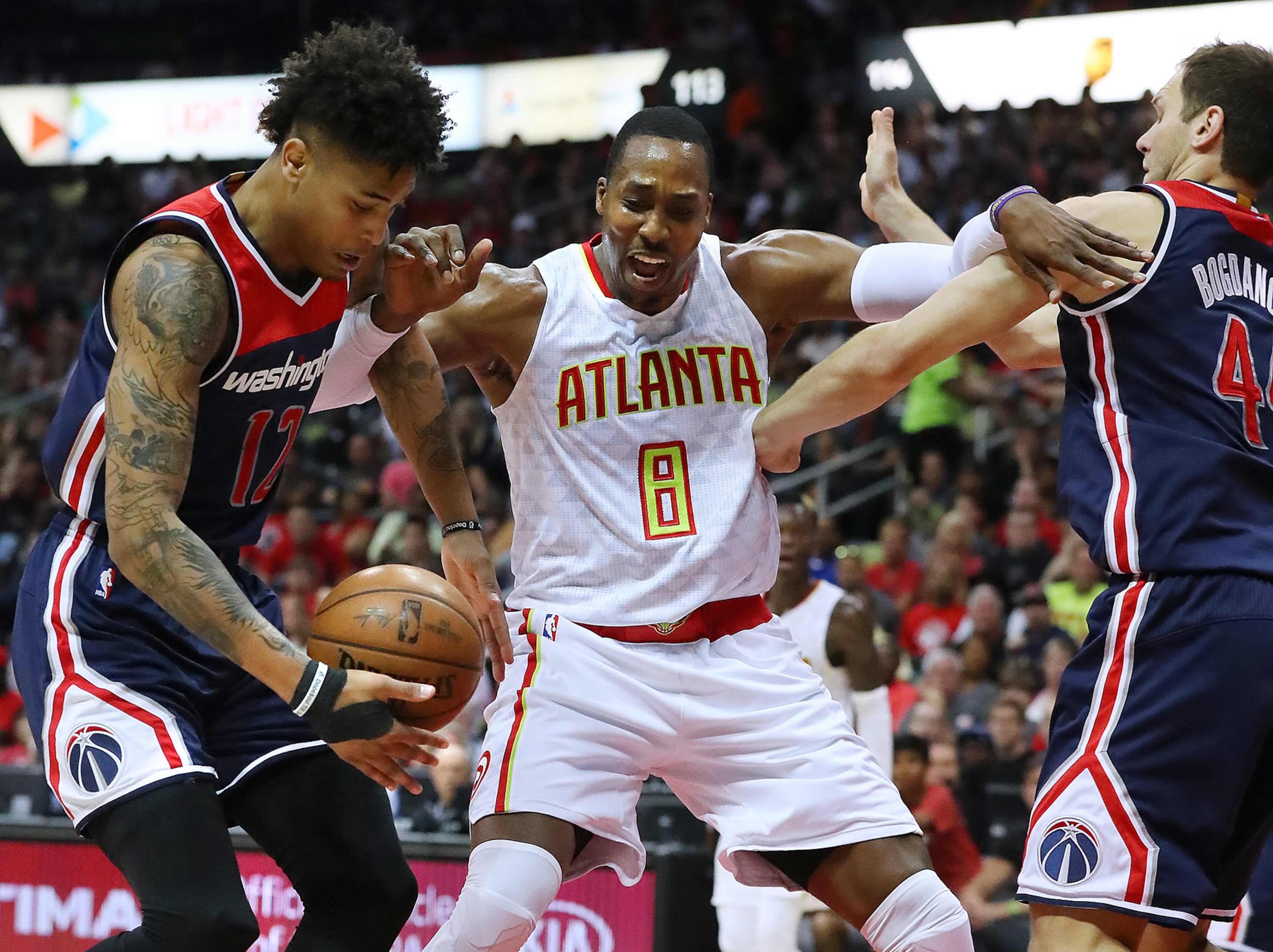 Atlanta Hawks center Dwight Howard battles Washington players Kelly Oubre Jr. (left) and Bojan Bogdanovic under the basket in Game 3 of a first-round playoff series in Atlanta. The Hawks won 116-98. (Curtis Compton/AJC 2017)