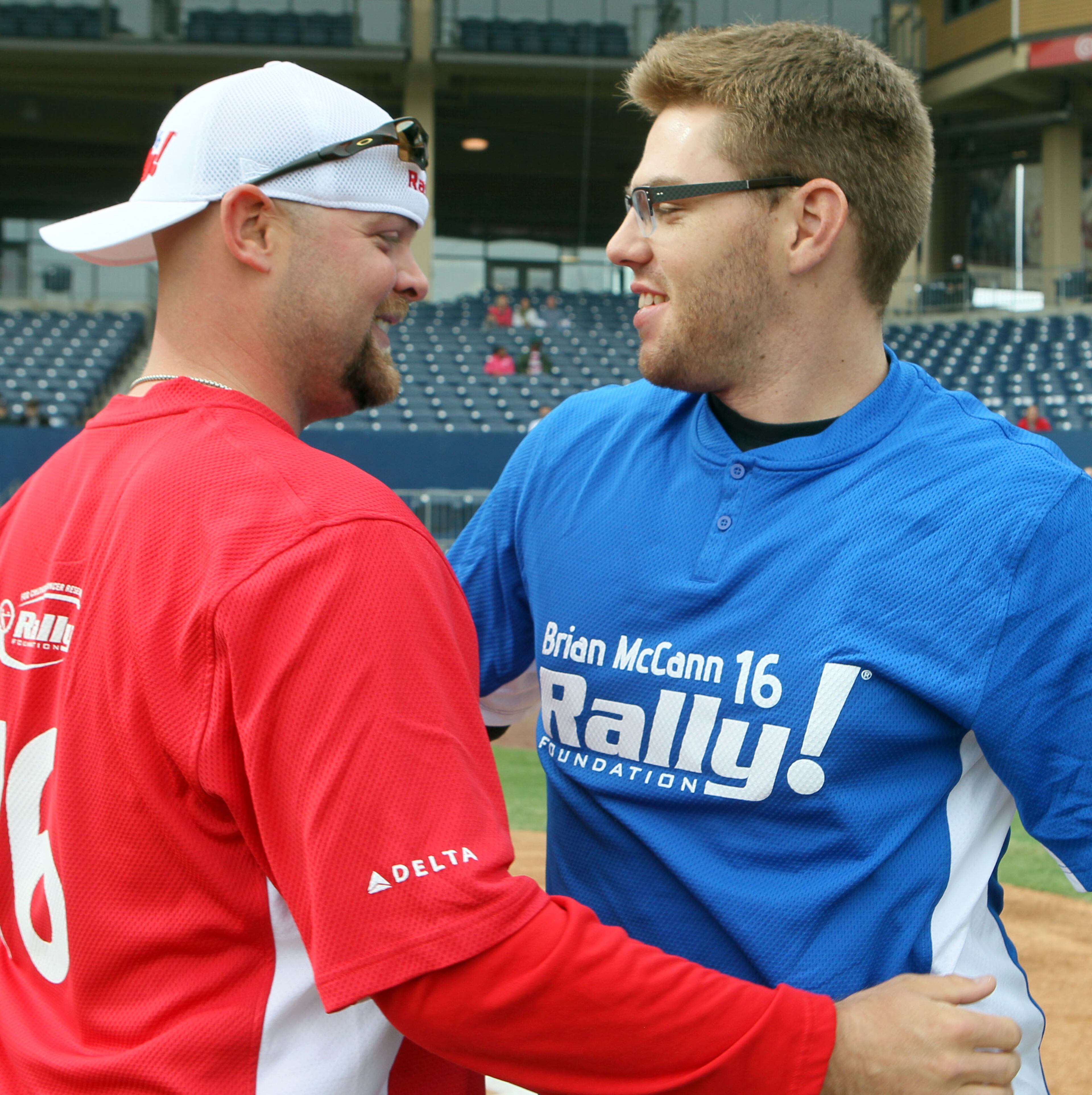 Brian McCann & Fredie Freeman hug before the 5th annual Brian McCann Rally Foundation Celebrity Softball Game at Coolray field in Lawrenceville on Saturday November 9th, 2013. Bert's Big Bats team played against Tug's Triple Threat in the event that raised funds for childhood cancer research.