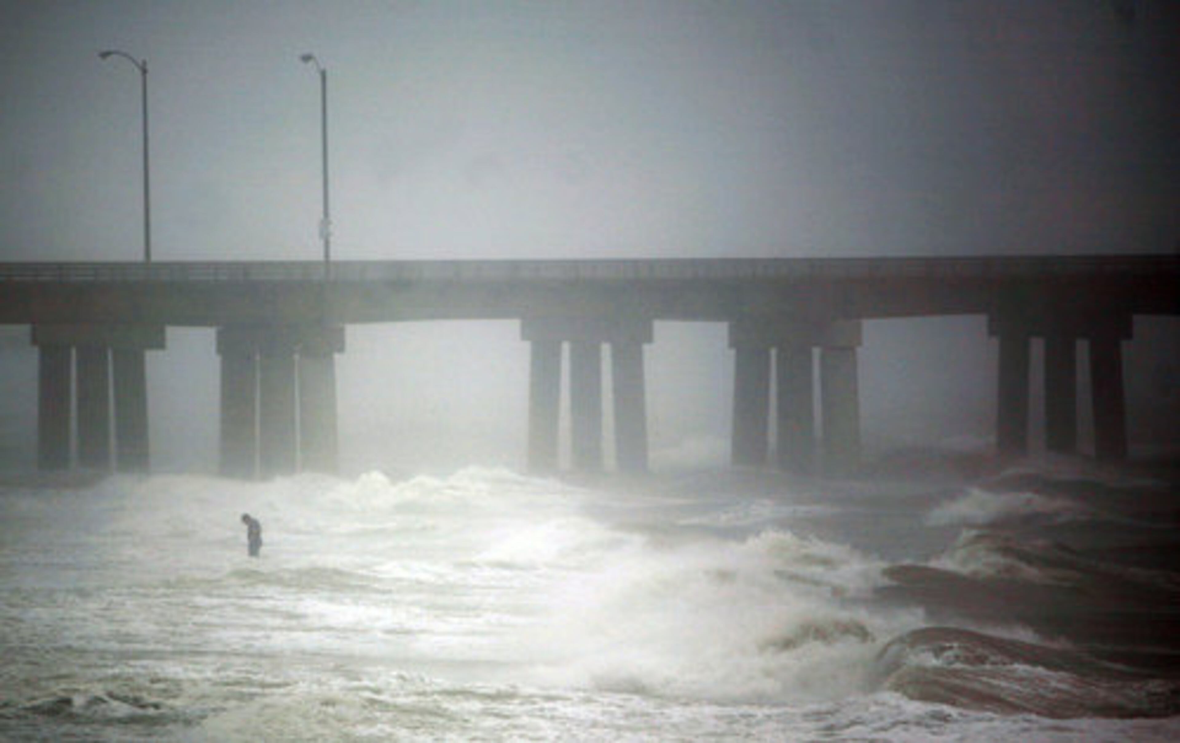 As Hurricane Irene spins north, a lone figure stands in the surf of the Chesapeake Bay near the Chesapeake Bay Bridge Tunnel in Virginia Beach, Va.