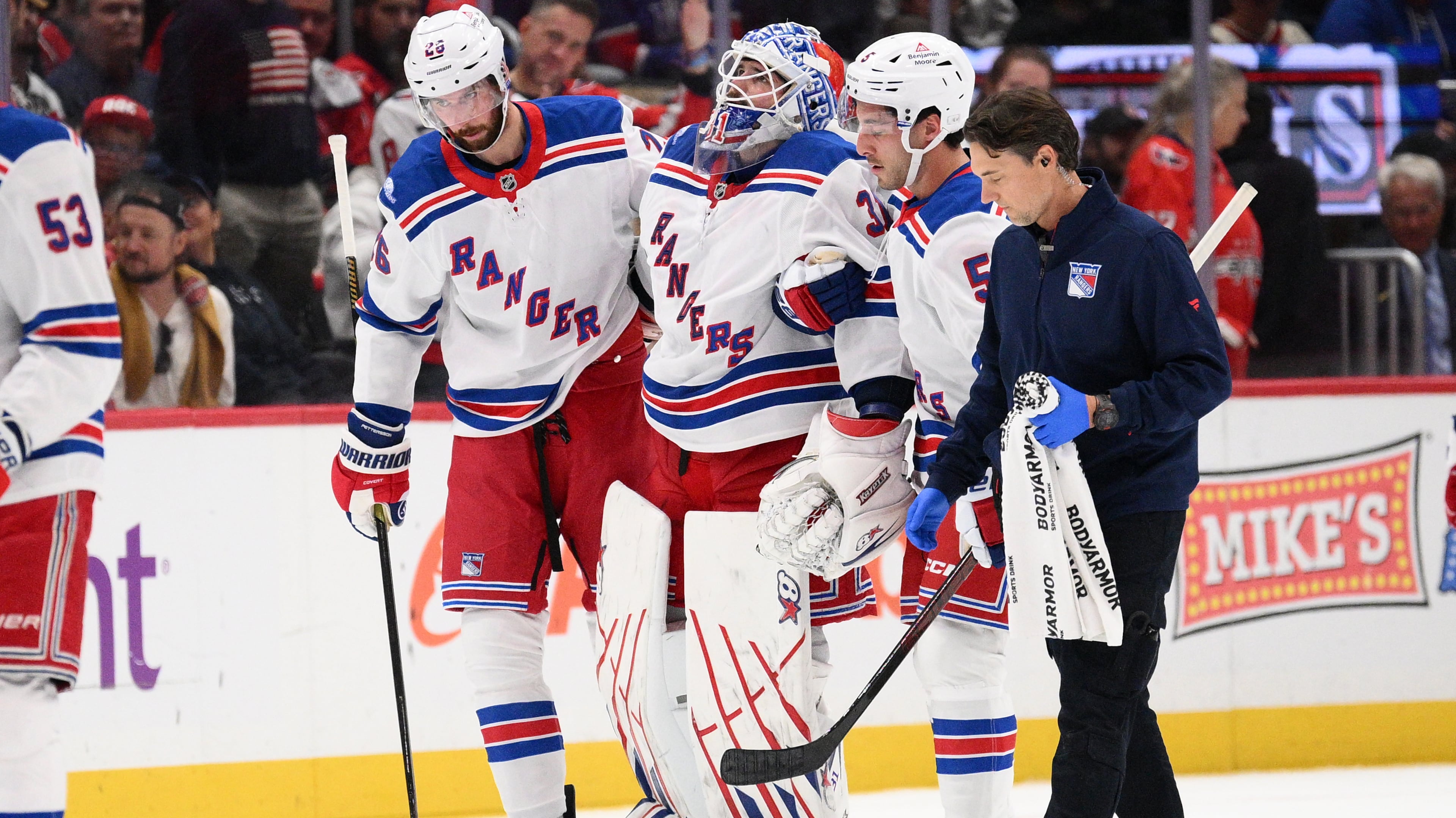 New York Rangers goaltender Igor Shesterkin, third from right, is helped to the bench after he was injured during the second period of an NHL hockey game against the Washington Capitals, Friday, Oct. 9, 2026, in Washington. (AP Photo/Nick Wass)