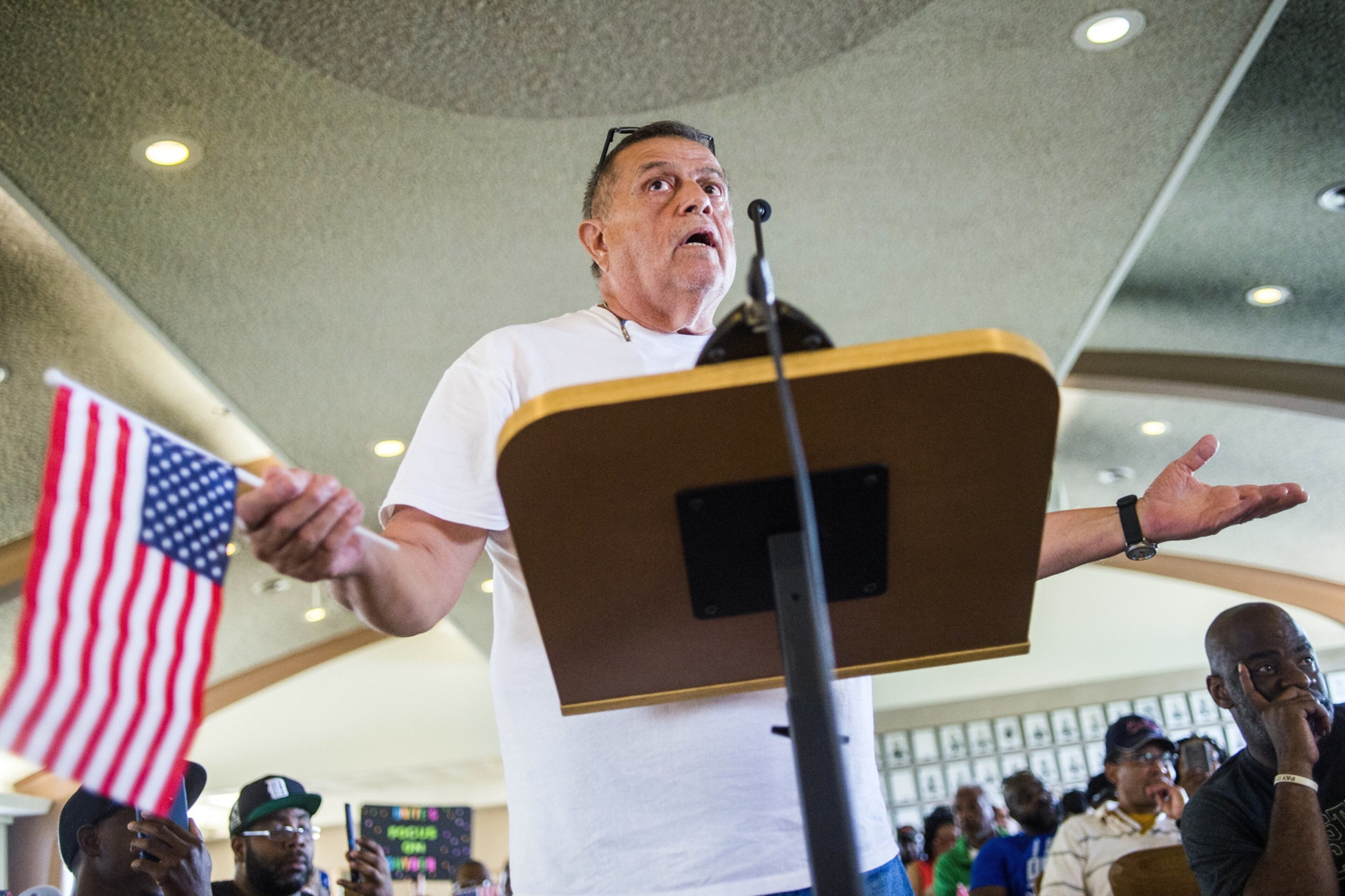 Flint resident Keith Pemberton, with an American flag, speaks his three-minute limit during a special Flint City Council meeting in City Hall in Flint, Mich., Wednesday, May 17, 2017. About 22 percent of excavations tied to Flint's lead-tainted water crisis have led to copper pipes that do not pose a threat of leaching lead, city records show. (Jake May/The Flint Journal-MLive.com via AP)