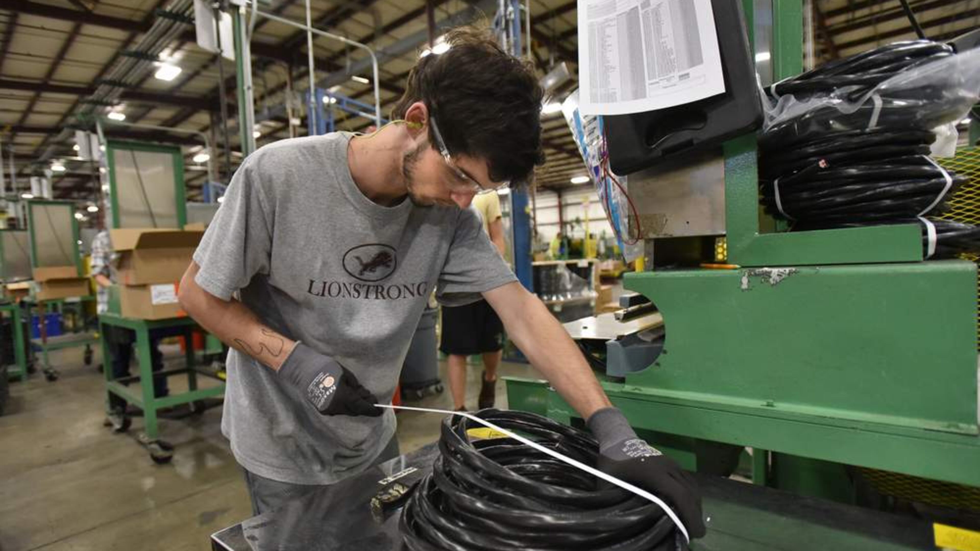 Zach Harness, 17, a student at Villa Rica High School, works at packing a product at a Carrollton plant. AJC photo.